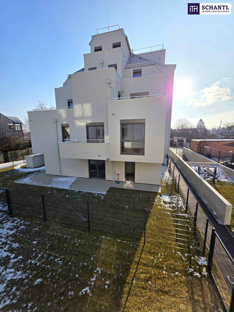 Moderne Wohnanlage mit gestufter Architektur und gepflegtem Gartenbereich im Sonnenlicht.