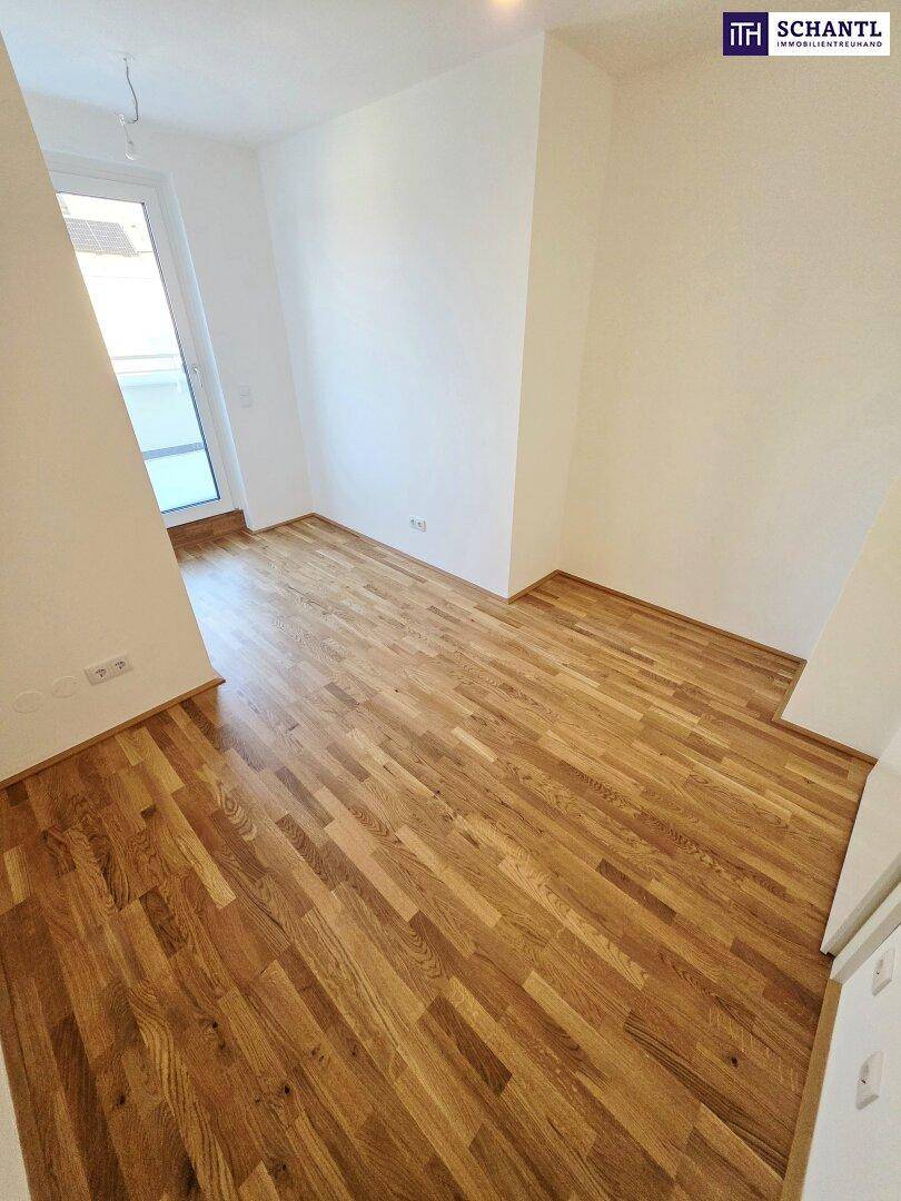 Geräumiger Raum mit Holzboden und Zugang zu einem Außenbereich, ideal für flexible Nutzung.