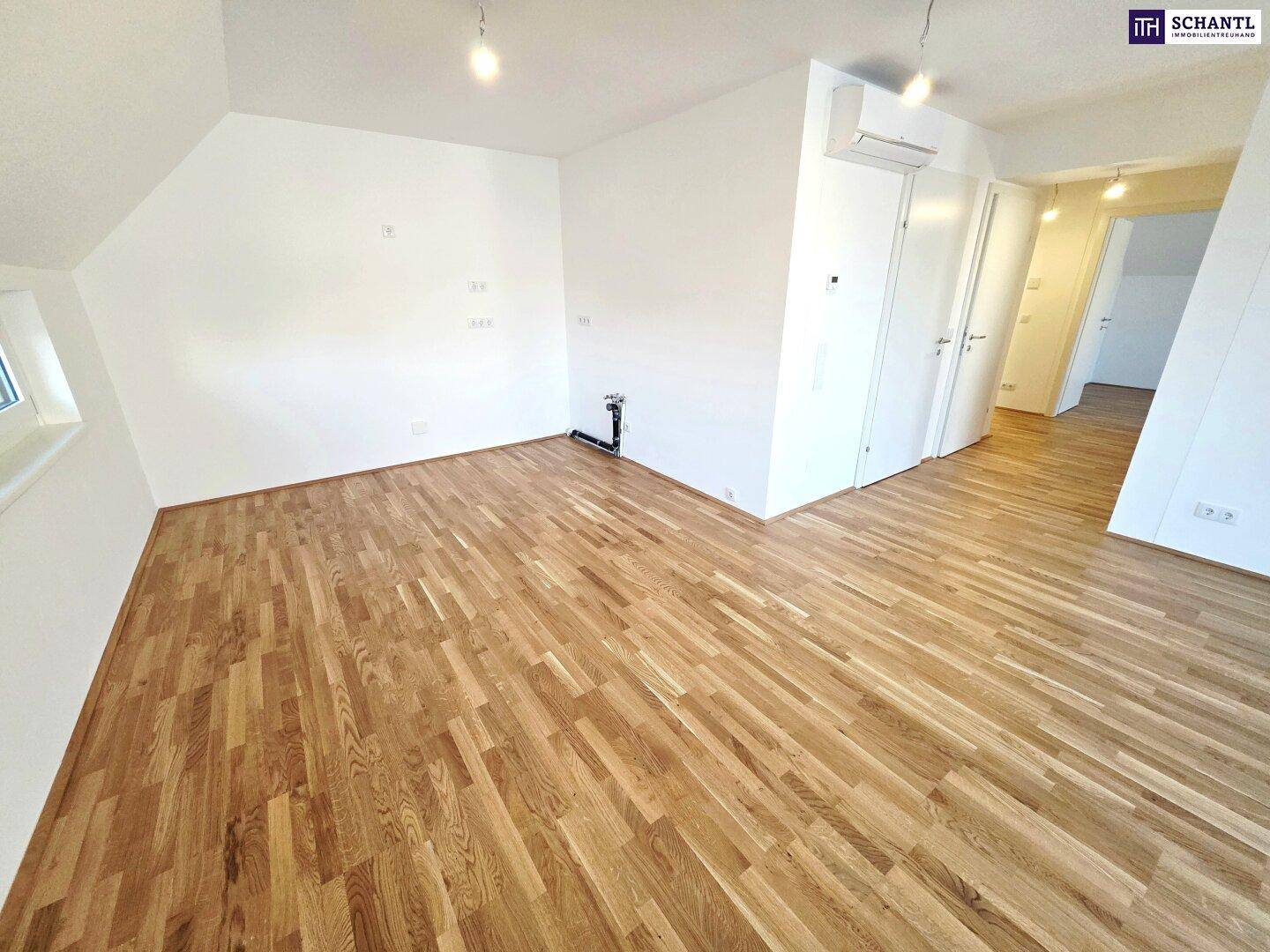 Geräumiges, helles Zimmer mit Holzboden und Dachschrägen, ideal für Wohn- oder Schlafbereich.