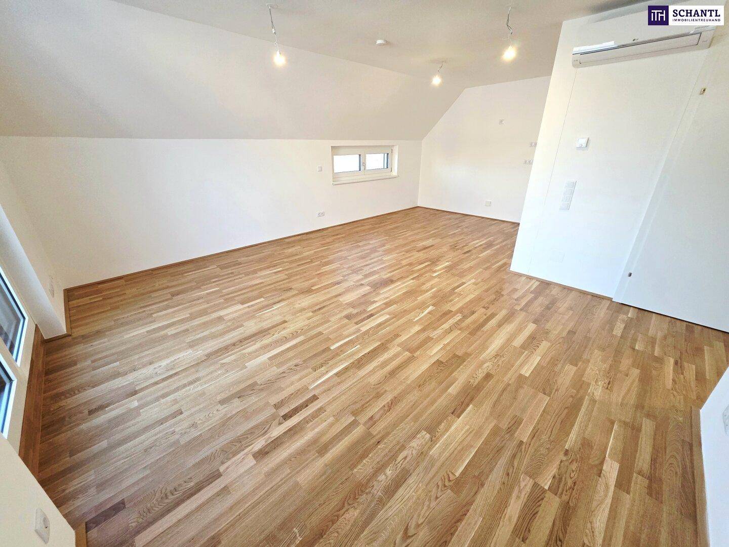Geräumiges Zimmer mit Parkettboden, Dachschrägen und Klimaanlage, bereit zur Nutzung.