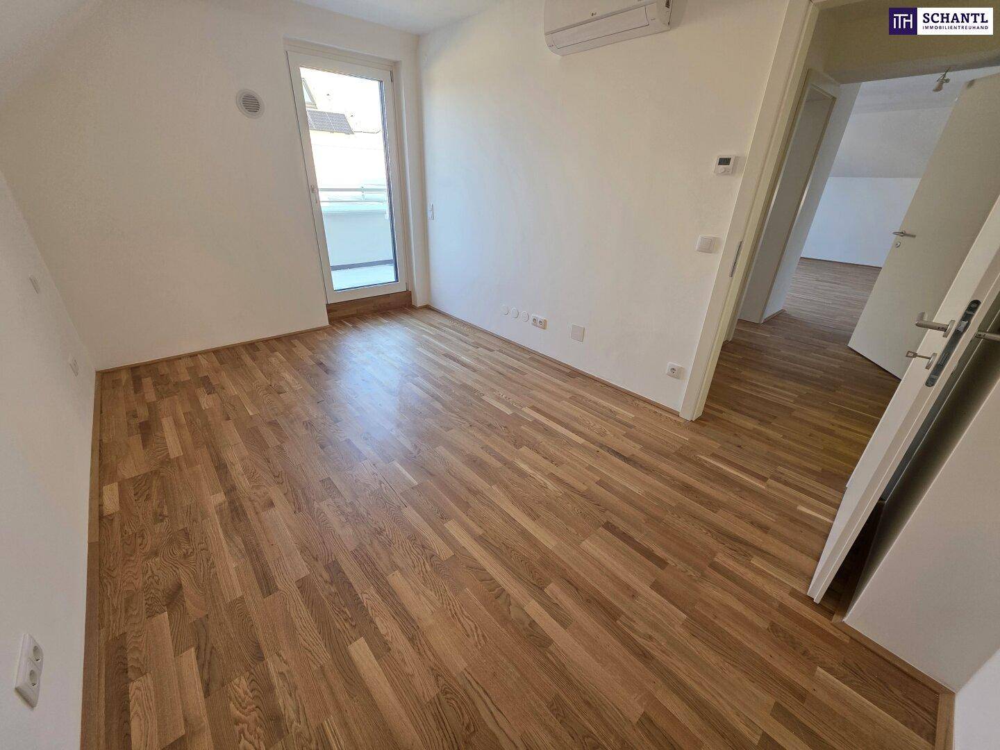 Helles Zimmer mit Parkettboden und Zugang zu einem Balkon, ideal für flexible Einrichtung.