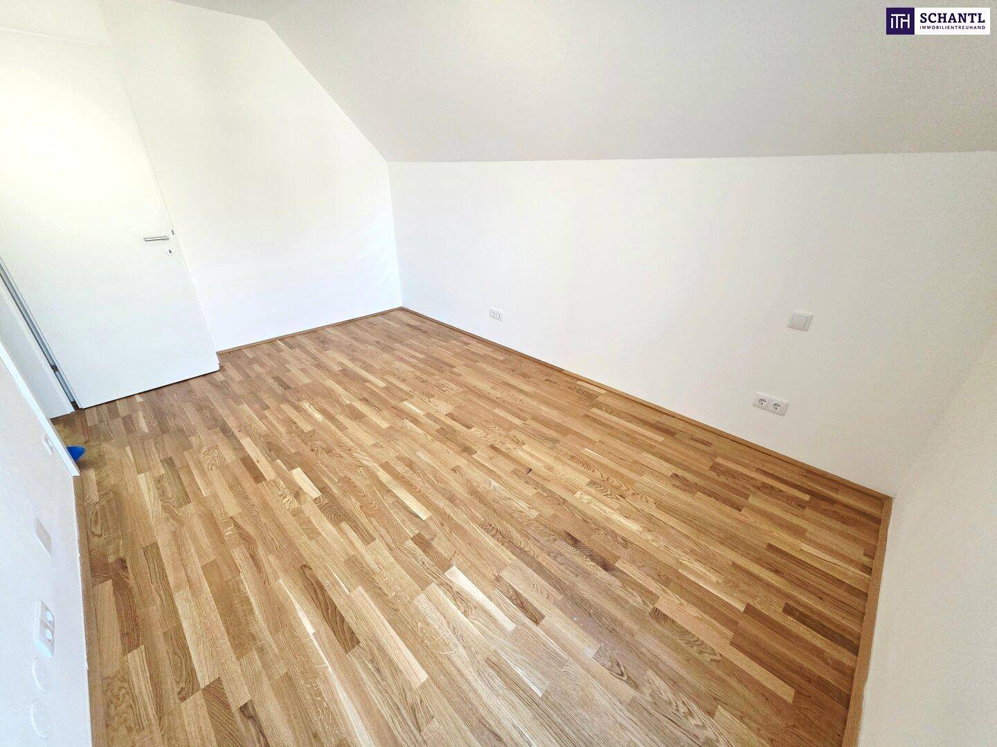 Leeres Zimmer mit Parkettboden und Dachschrägen, bietet Potenzial für individuelle Nutzung.