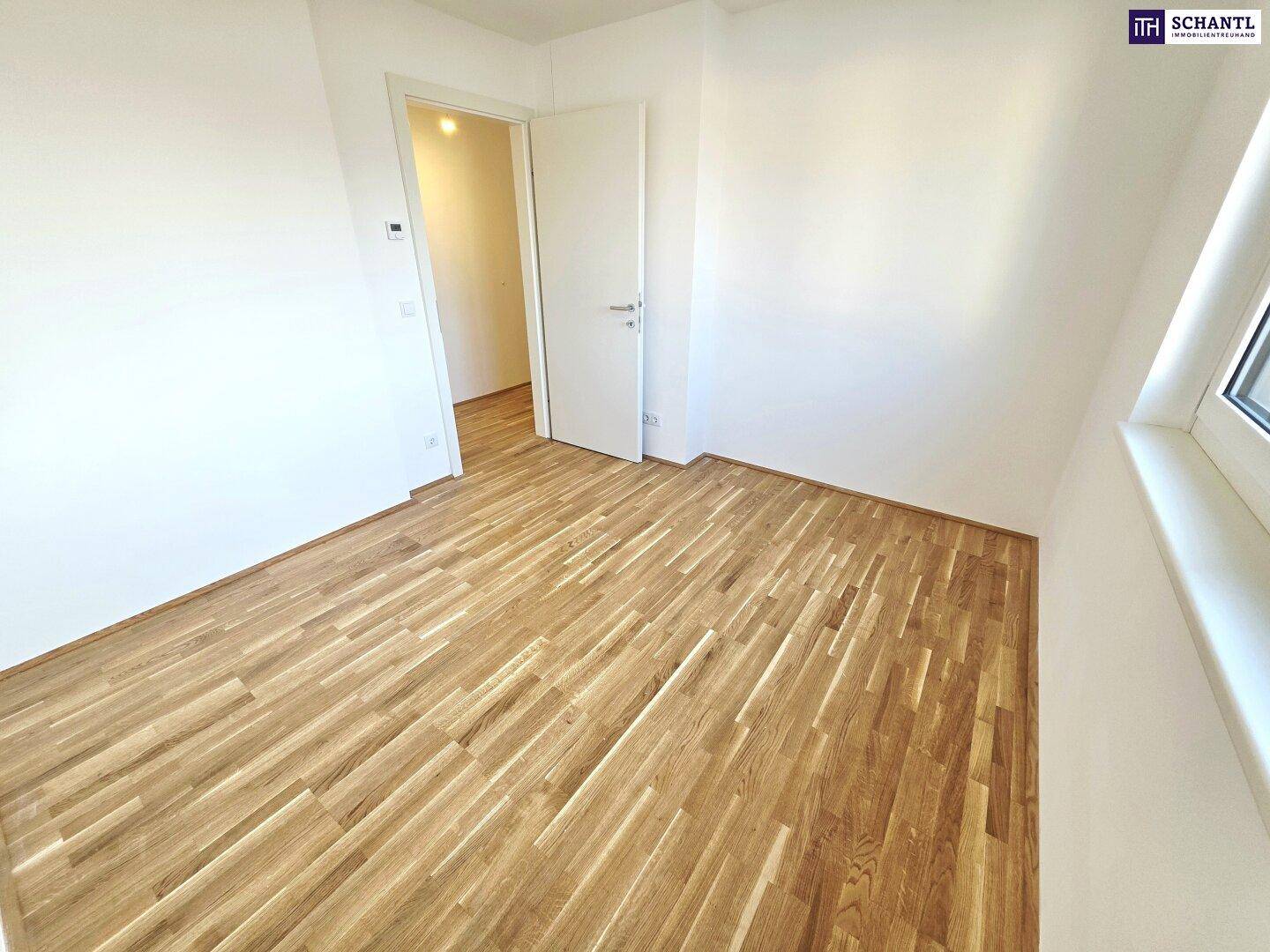 Leeres Zimmer mit Parkettboden und weiß gestrichenen Wänden, ideal als Schlafzimmer.