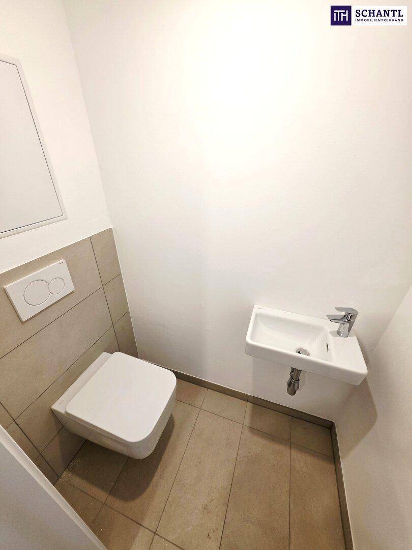 Kleines Gäste-WC mit wandmontierter Toilette und kompaktem Waschbecken.