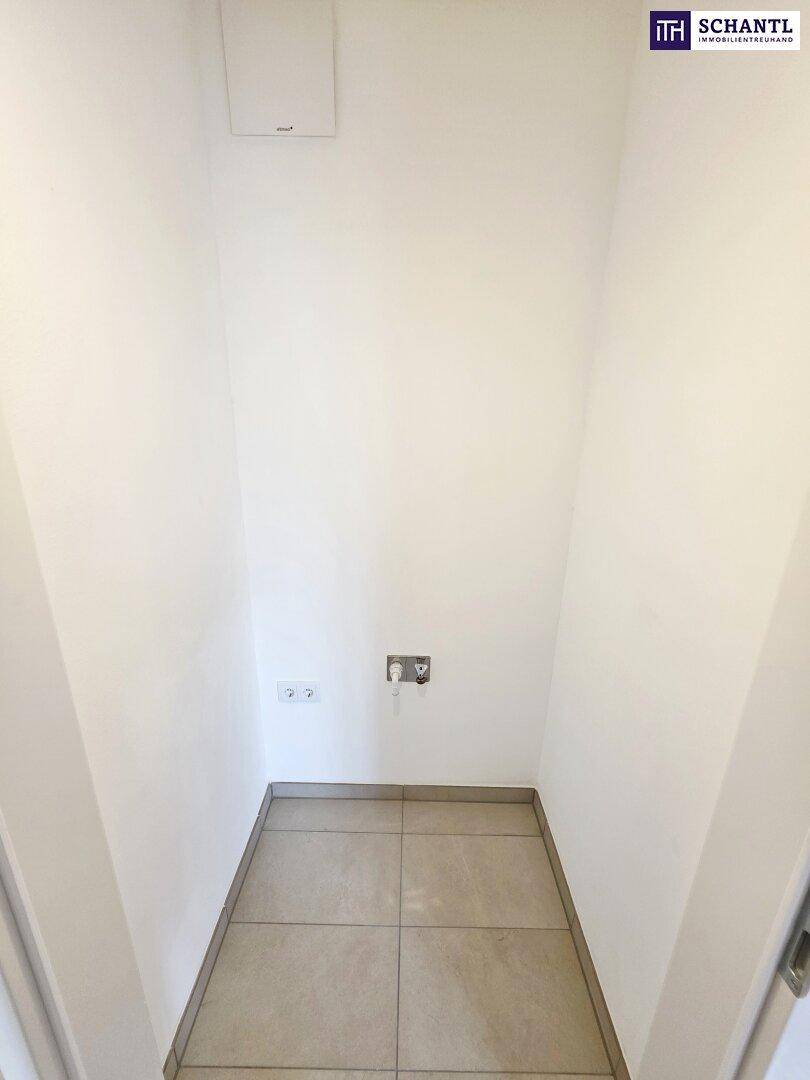 Kleiner Abstellraum mit Fliesenboden und Anschlüssen, ideal für Waschmaschine oder Lagerung.