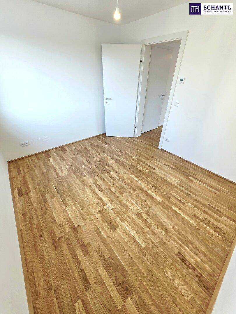 Geräumiges Zimmer mit Parkettboden und weiß gestrichenen Wänden, bereit zur Einrichtung.