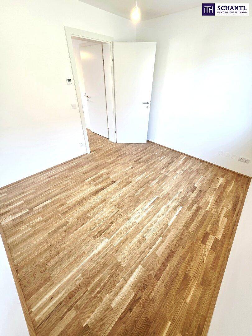 Helles Zimmer mit Parkettboden und weiß gestrichenen Wänden, ideal als Schlafzimmer.