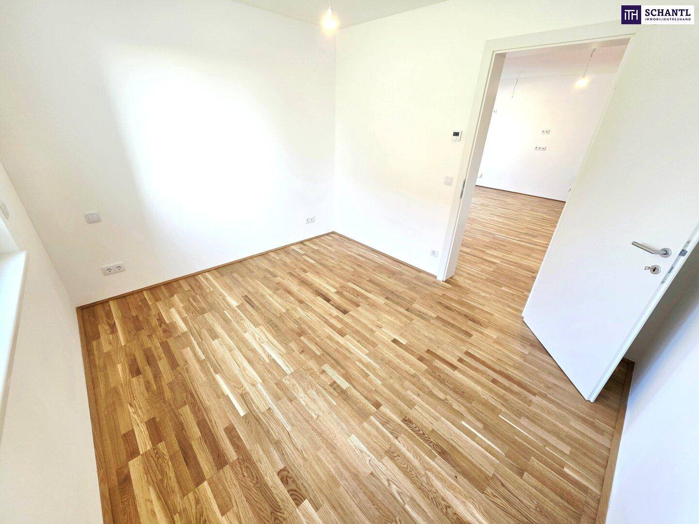 Helles Zimmer mit Parkettboden und weiß gestrichenen Wänden, ideal als Schlafzimmer.