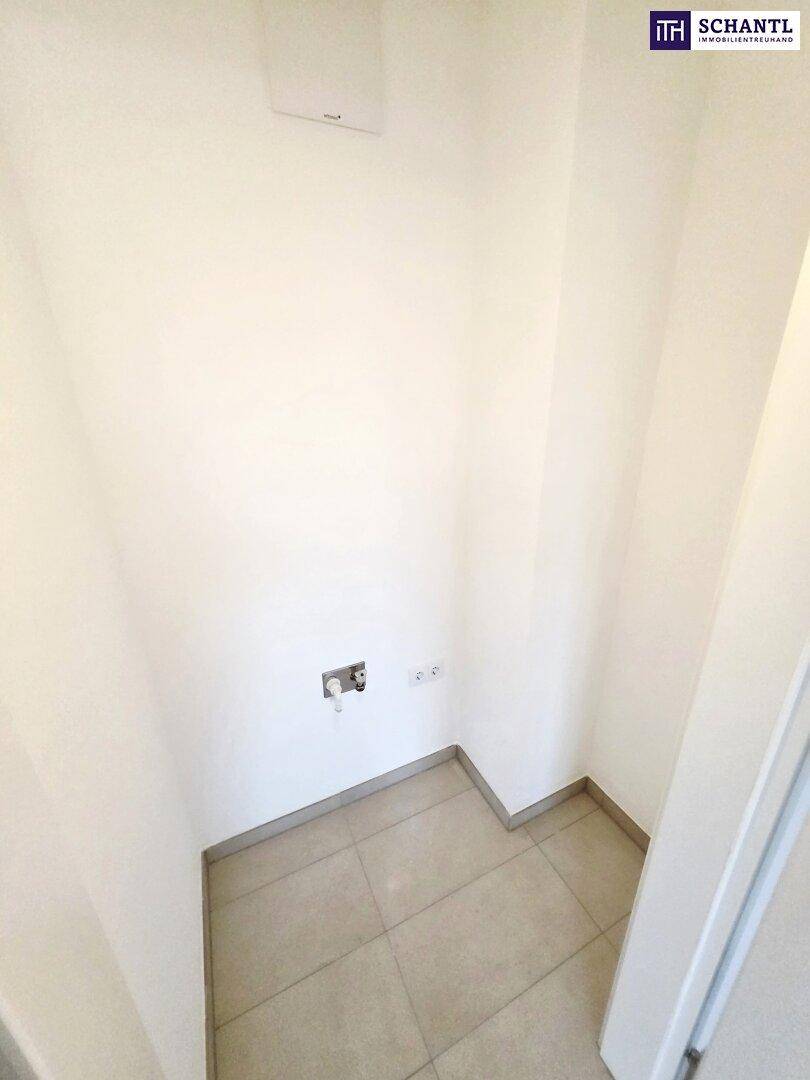 Kleiner Abstellraum mit Fliesenboden und Anschlüssen für Waschmaschine oder Trockner.