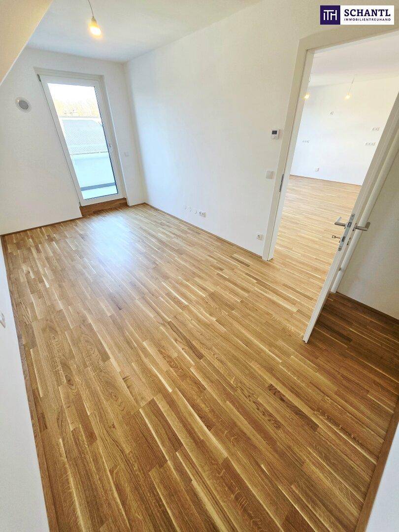 Unmöblierter Raum mit Parkettboden und Zugang zu einem Balkon oder einer Terrasse.