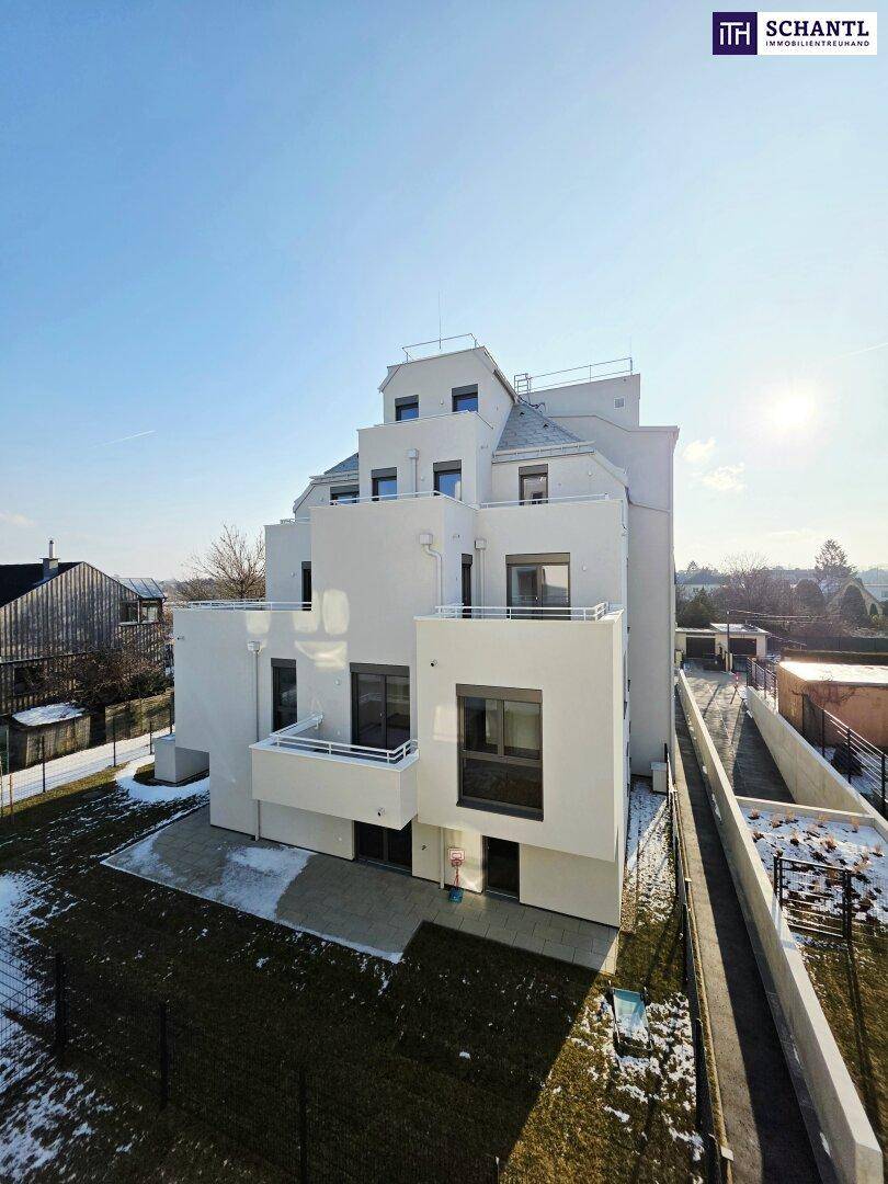 Moderne Wohnanlage mit gestufter Architektur und weißer Fassade an einem sonnigen Wintertag.