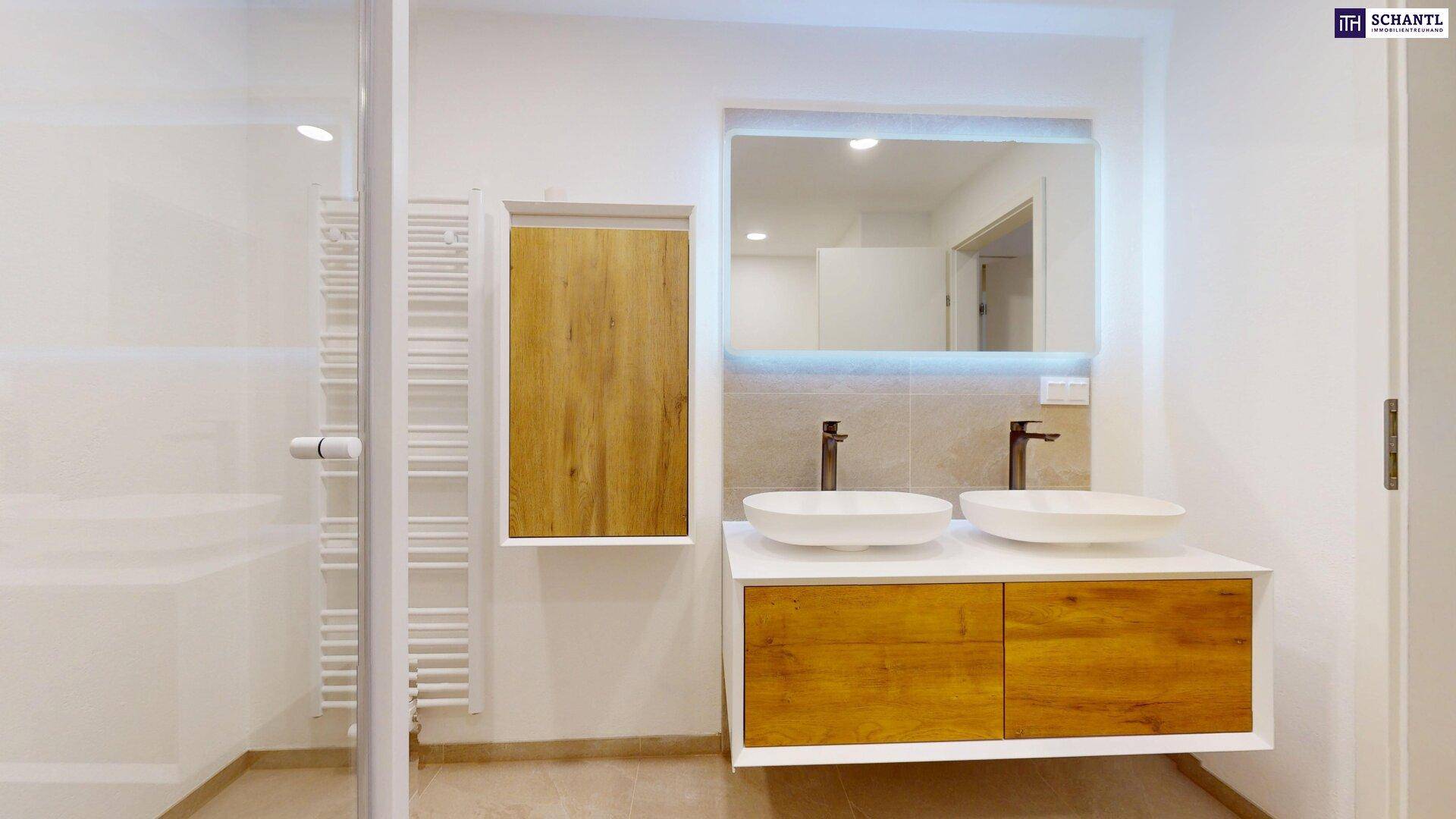 Modernes Badezimmer mit Doppelwaschbecken, großem Spiegel und beheiztem Handtuchhalter.