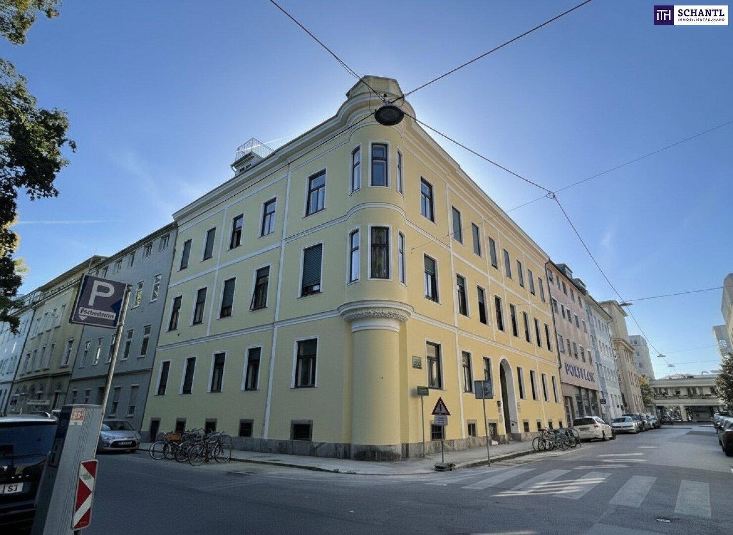 Historisches Eckgebäude mit gelber Fassade und traditioneller Architektur in städtischer Umgebung.