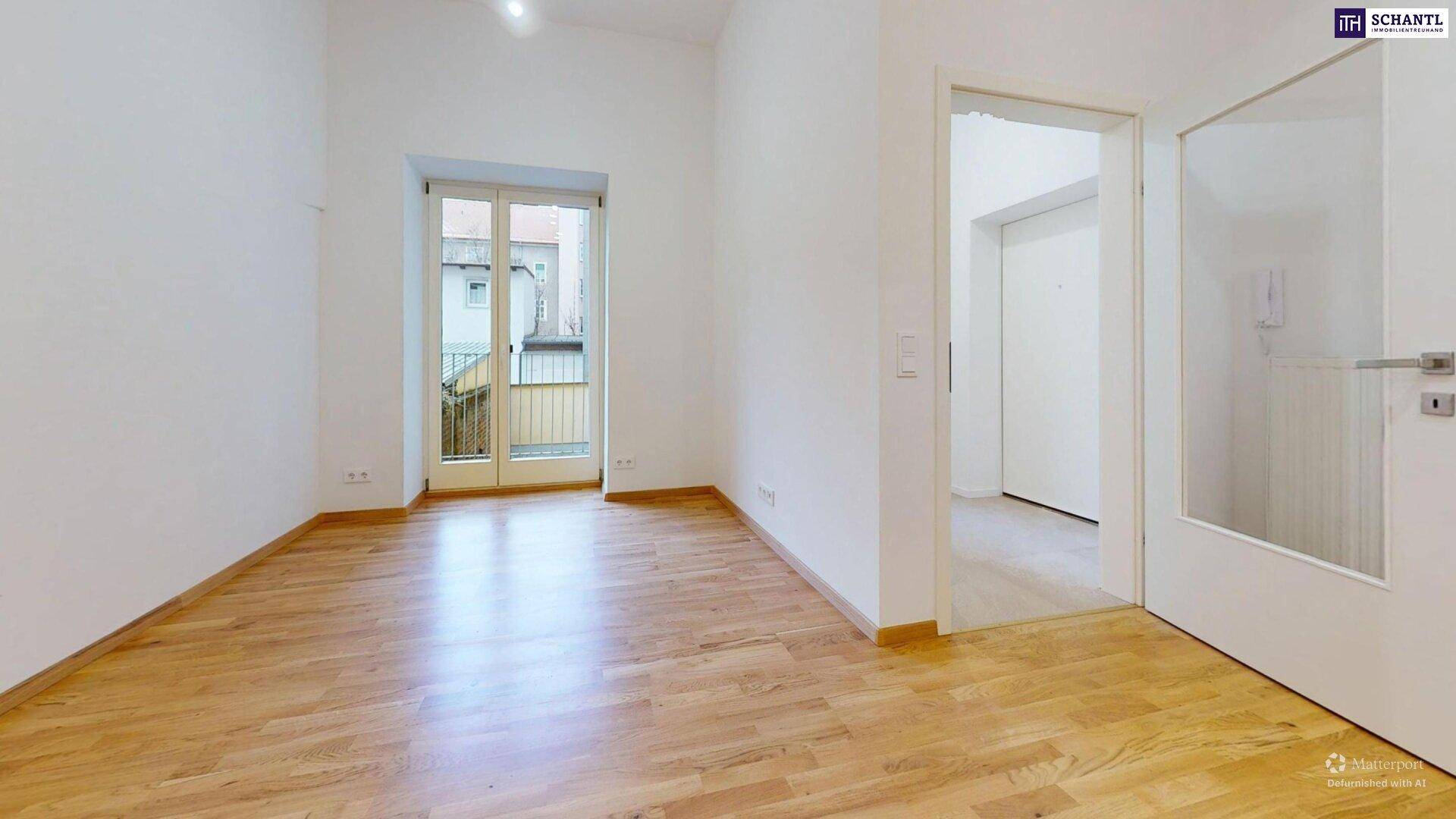 Heller Raum mit Holzboden und Zugang zu einem kleinen Balkon, vielseitig nutzbar.