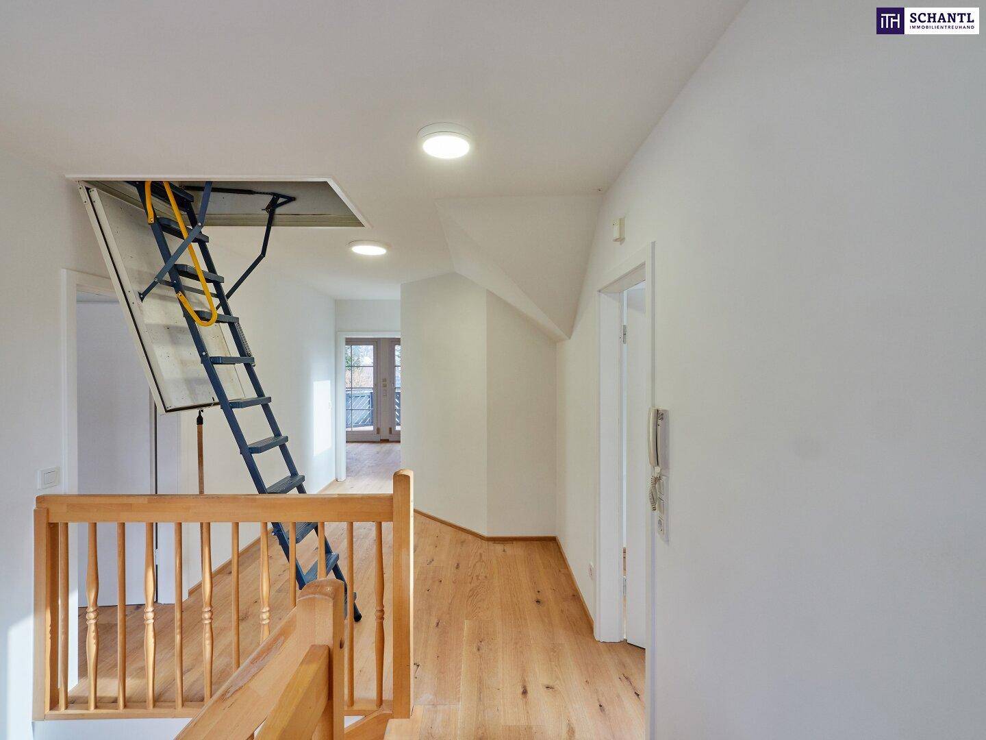 Heller Flur im Obergeschoss mit Holzboden und Zugang zum Dachboden über eine Ausziehtreppe.
