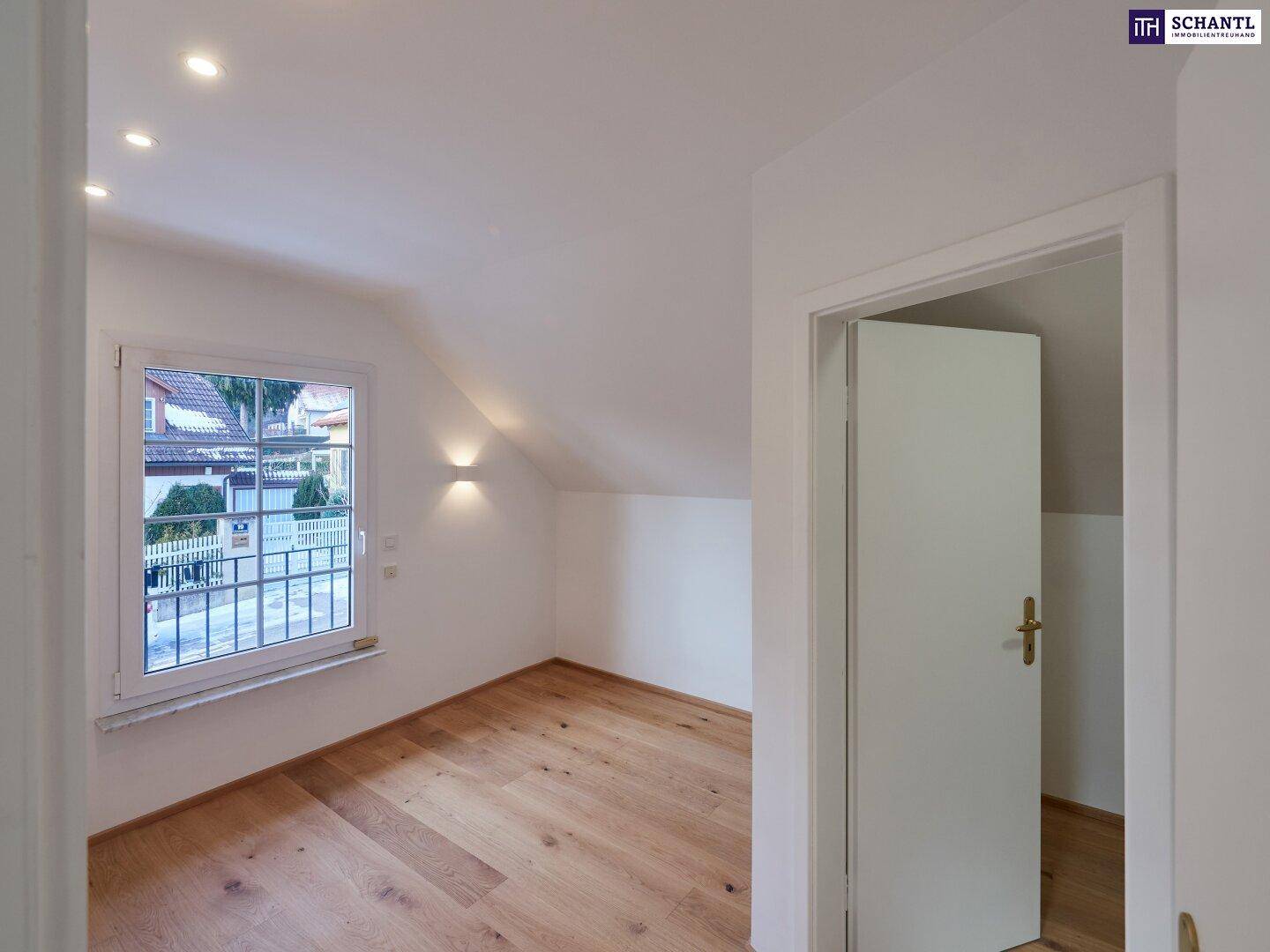 Helles Schlafzimmer mit Holzboden und schrägen Wänden, typisch für ein Dachgeschoss.