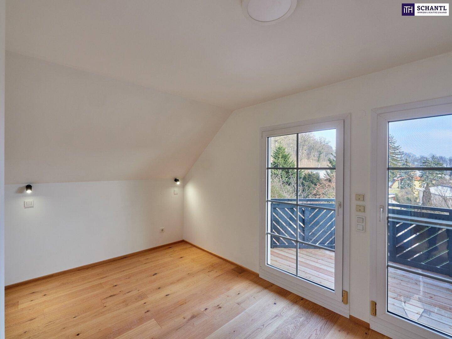 Helles Schlafzimmer mit Holzboden und direktem Zugang zu einem Balkon mit Aussicht.