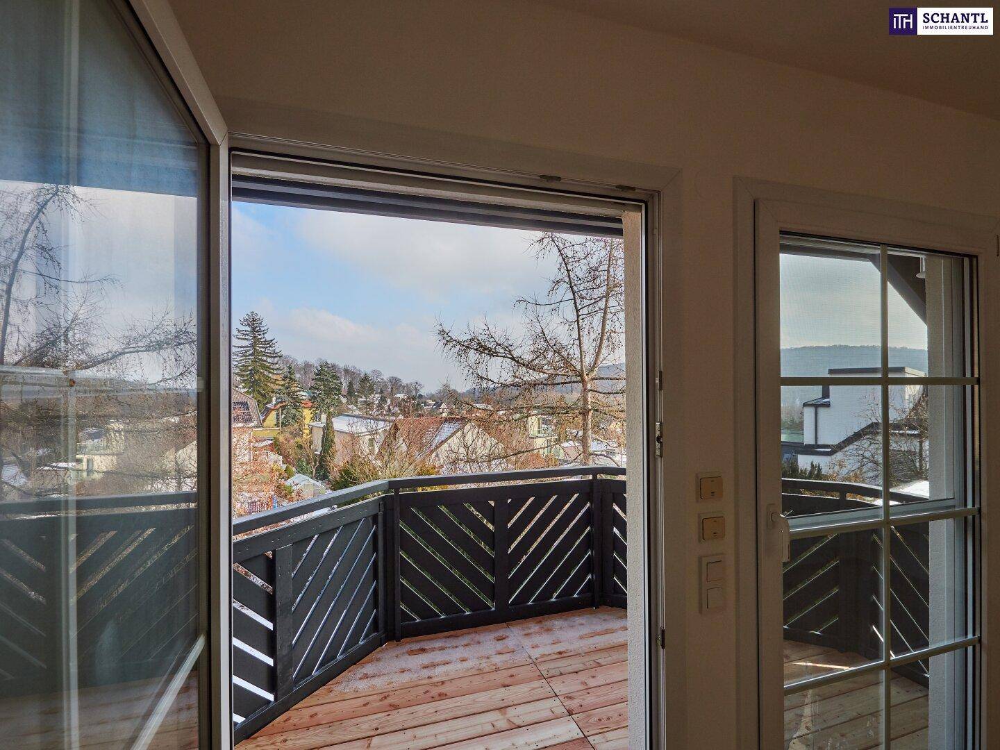 Balkon mit Holzboden und Geländer, bietet einen weiten Blick über die verschneite Landschaft.