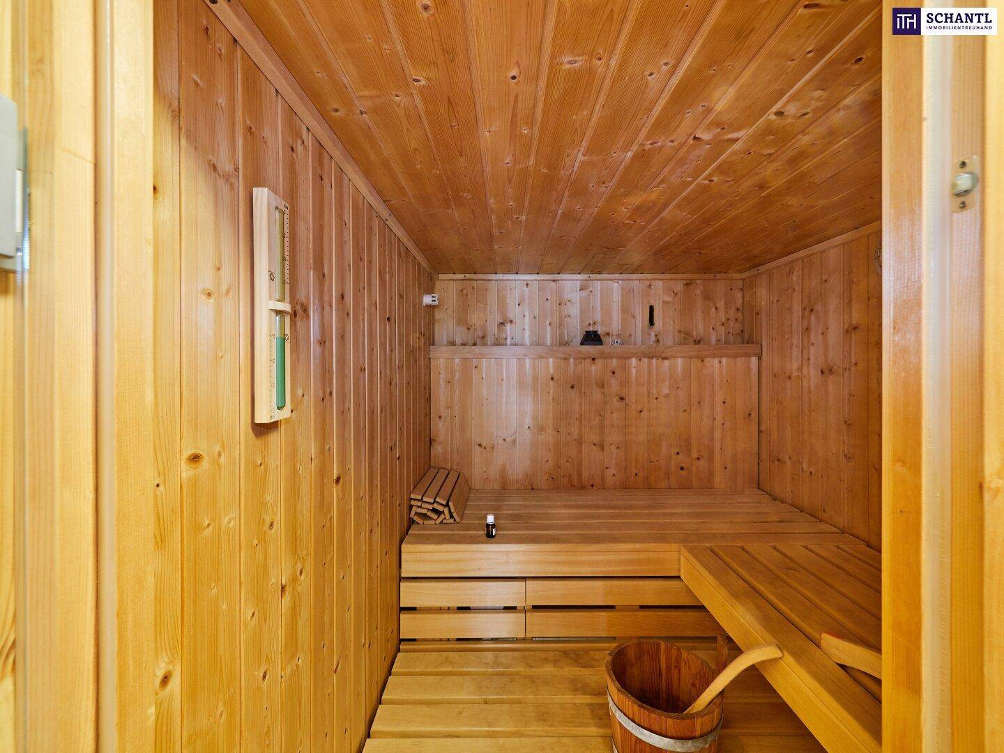 Geräumige Holzsauna mit Bänken und traditionellem Saunaofen für entspannende Momente.