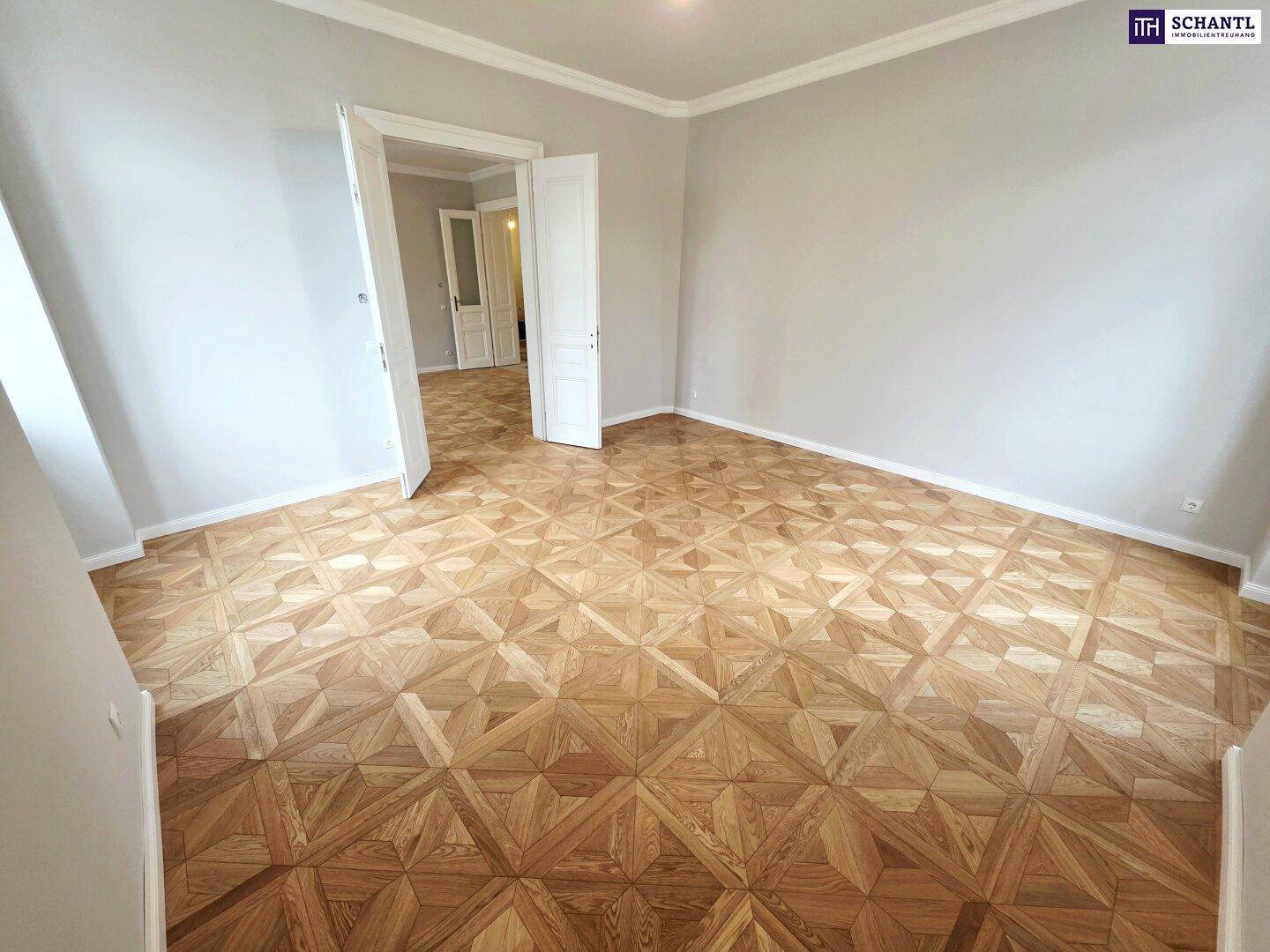 Helles Zimmer mit kunstvollem Parkettboden und hohen Decken, ideal für Wohn- oder Schlafbereich.