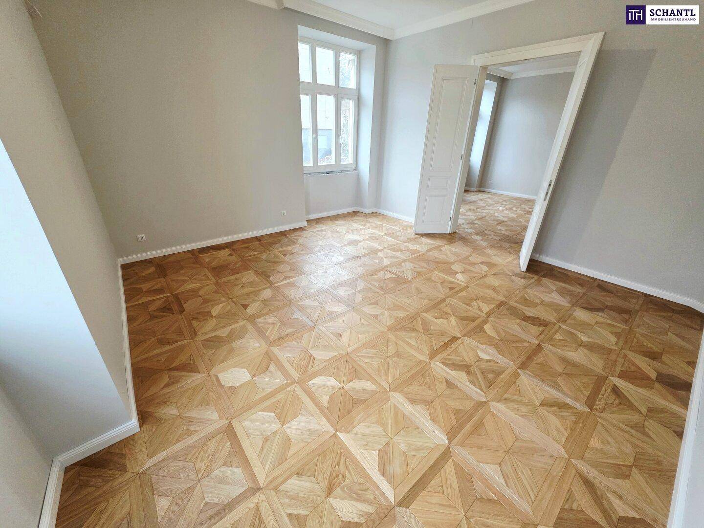 Helles Zimmer mit großen Fenstern, elegantem Parkettboden und hohen Decken, frisch renoviert.