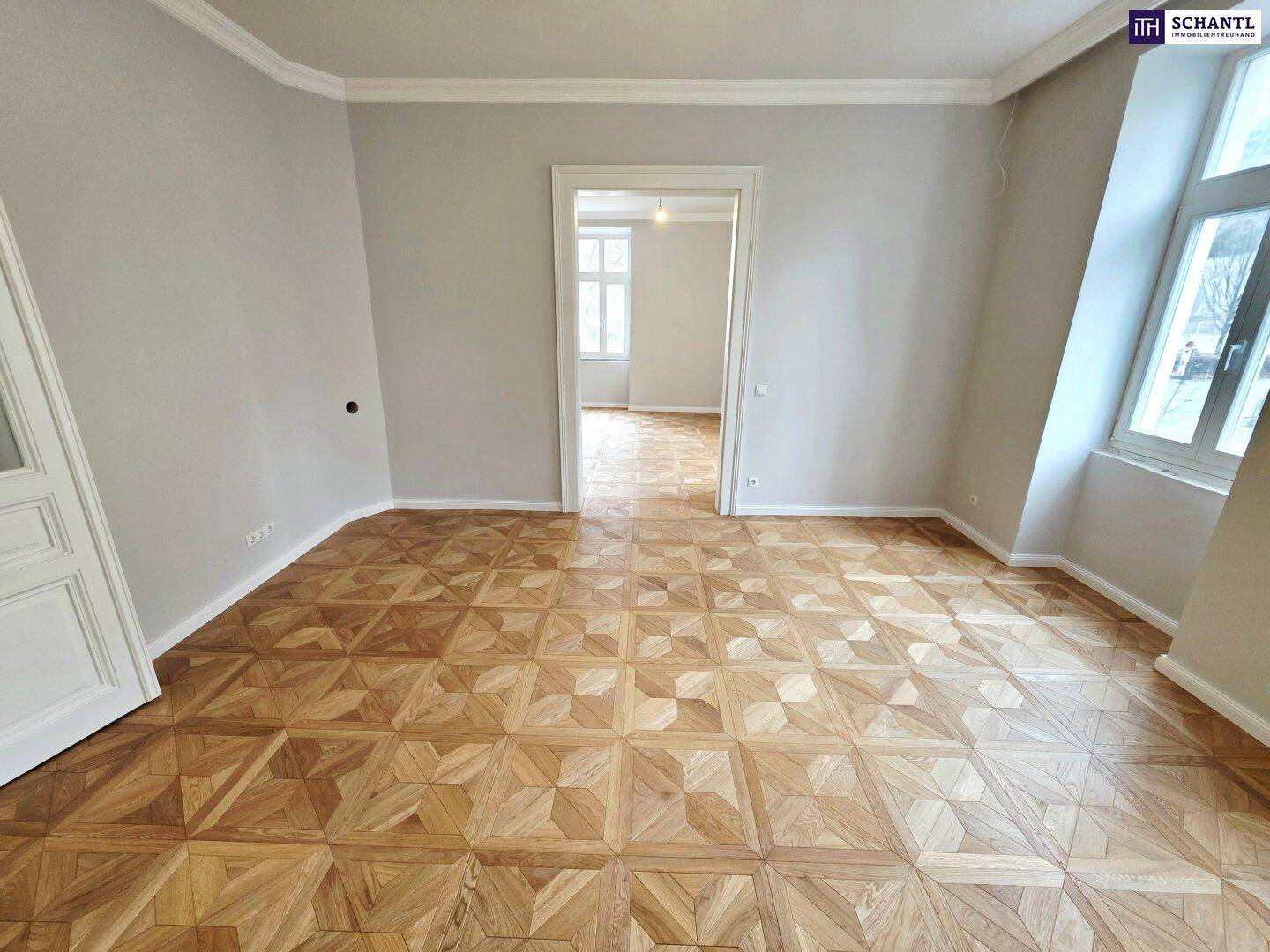 Helles Zimmer mit großen Fenstern, elegantem Parkettboden und hohen Decken, frisch renoviert.