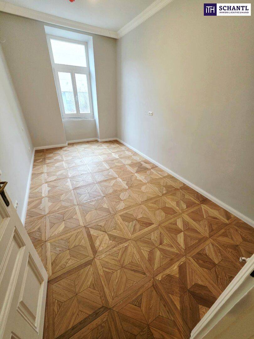 Helles Zimmer mit großen Fenstern, elegantem Parkettboden und hohen Decken, frisch renoviert.