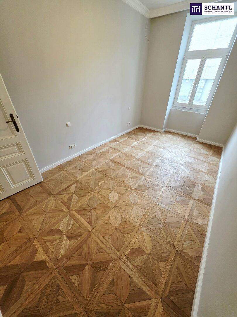 Helles Zimmer mit großen Fenstern, elegantem Parkettboden und hohen Decken, frisch renoviert.