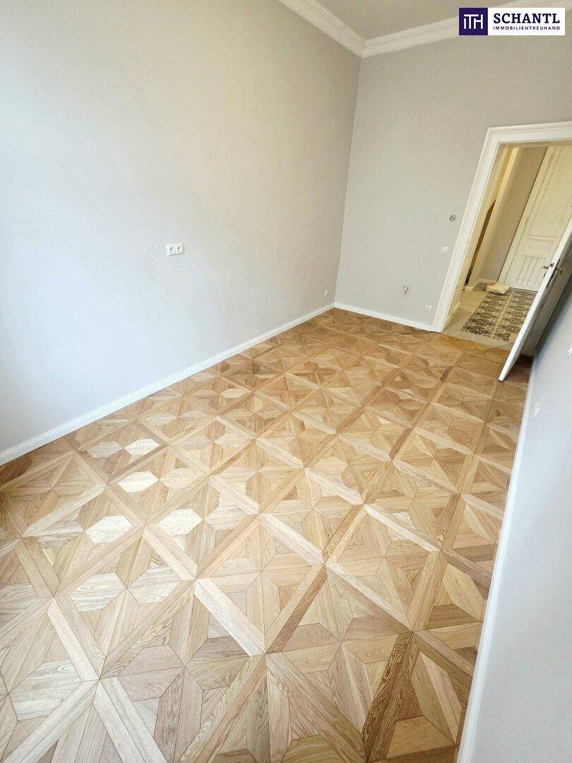 Geräumiges Zimmer mit elegantem Parkettboden und hohen Decken, bereit zur Einrichtung.