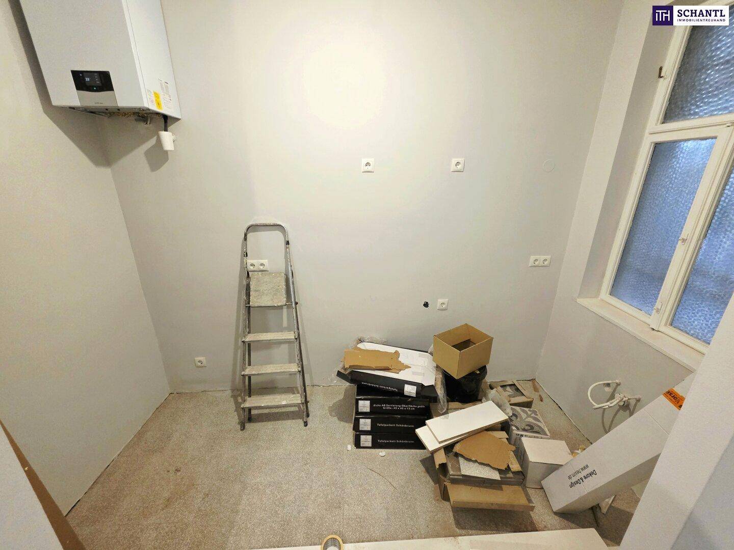 Raum im Umbau mit Heizungsanlage, Fenster und Baumaterialien, ideal als Hauswirtschaftsraum.