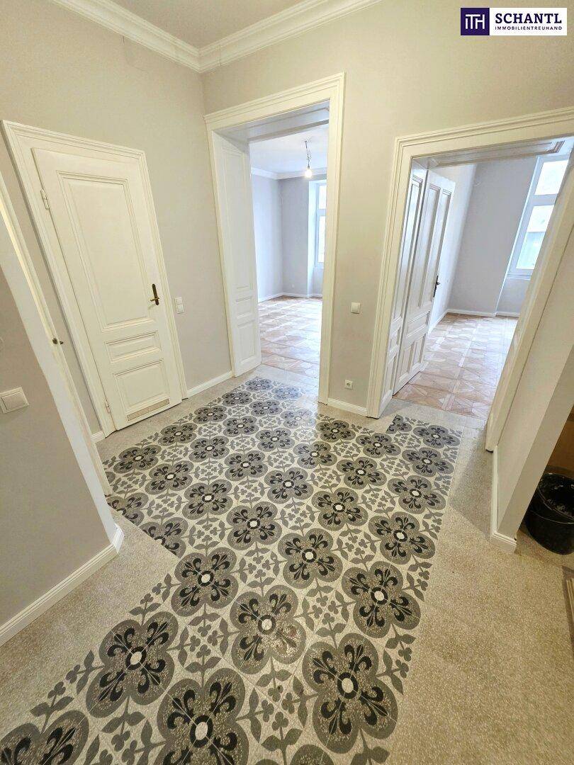 Heller Flur mit gemusterten Fliesen und Zugang zu mehreren Zimmern, typisch für Altbauwohnungen.