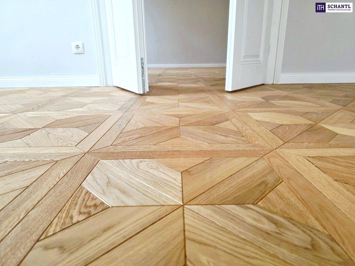 Detailaufnahme des kunstvollen Parkettbodens mit geometrischem Muster in einem renovierten Raum.