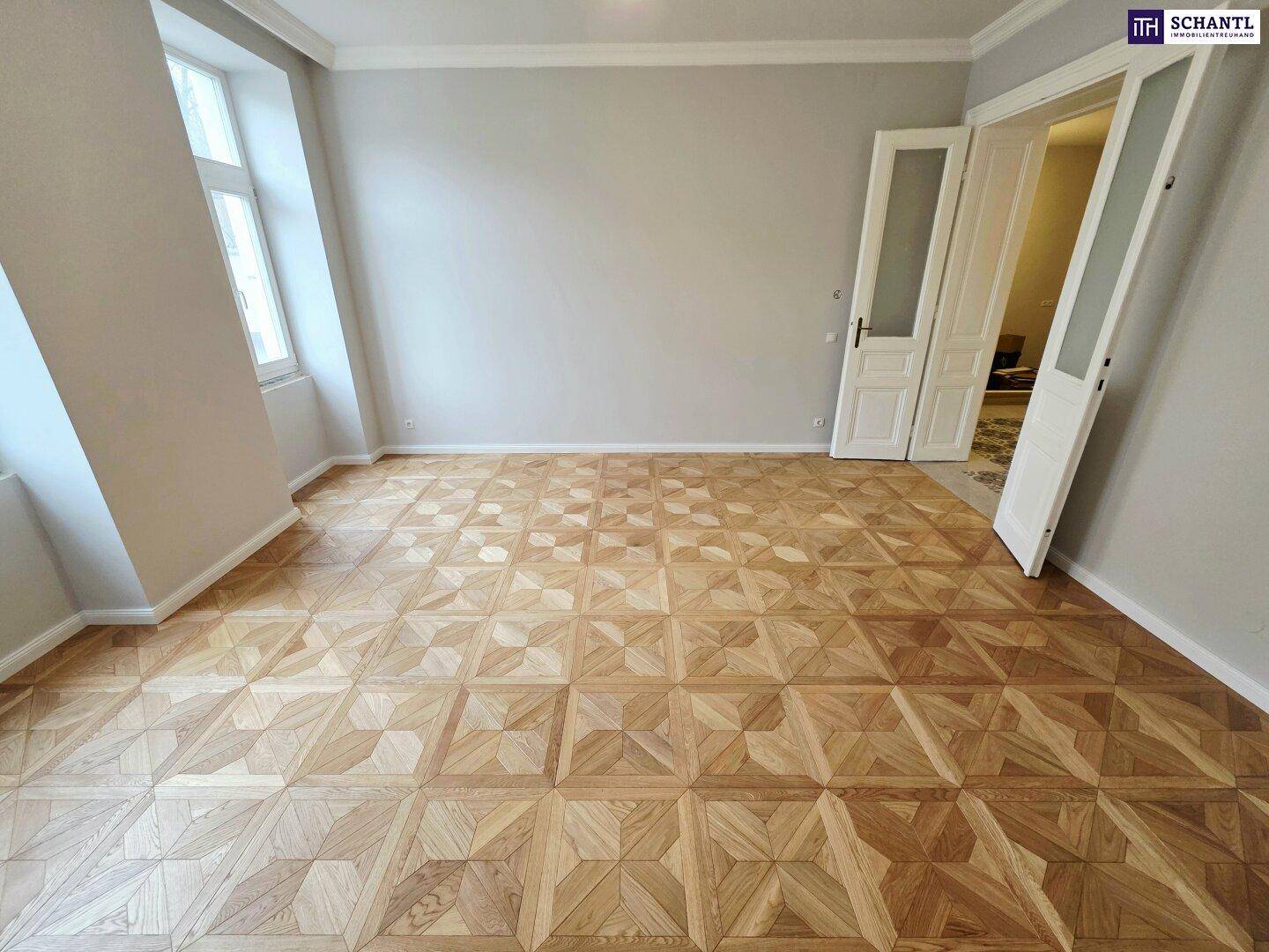 Helles Zimmer mit großen Fenstern, elegantem Parkettboden und hohen Decken, frisch renoviert.