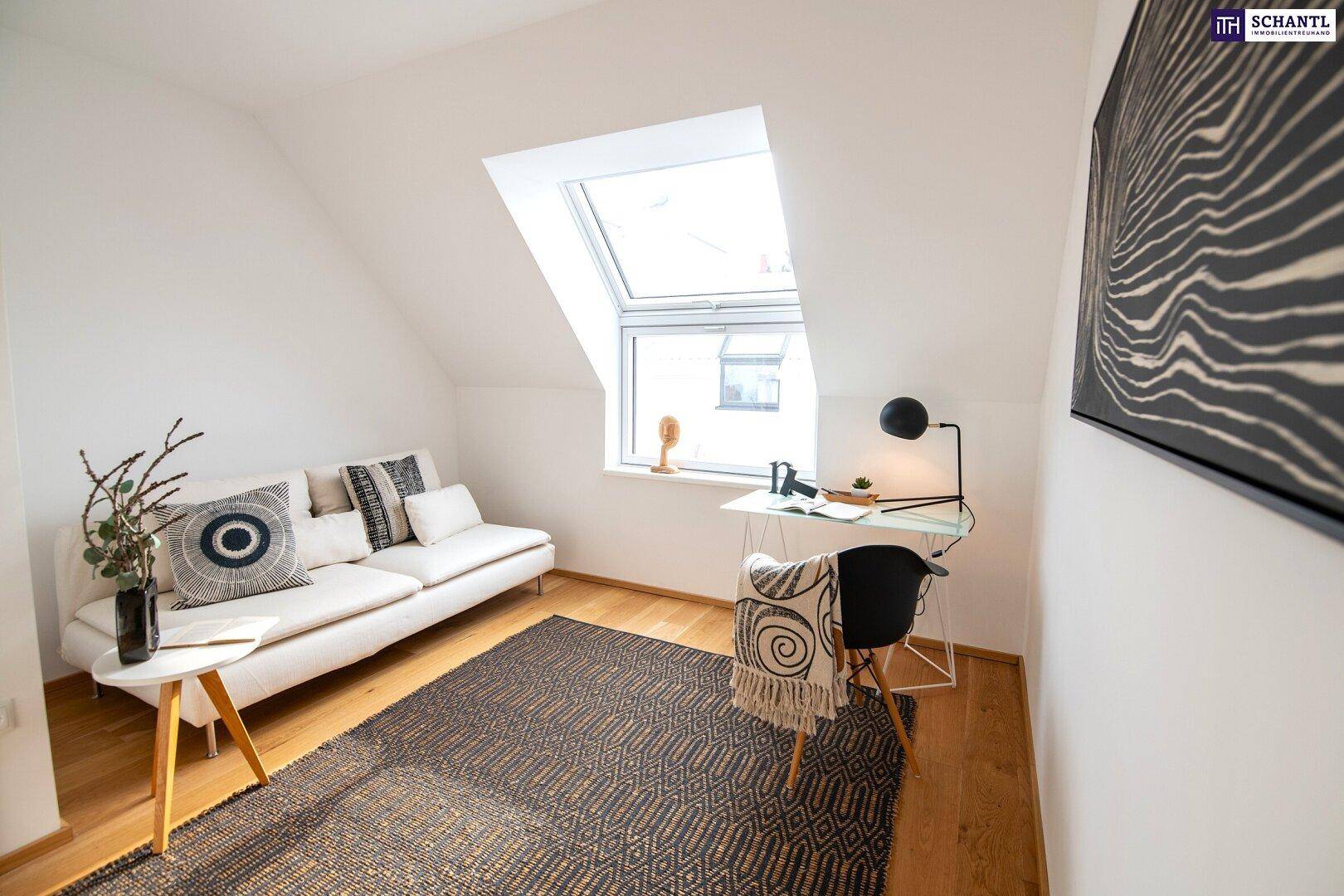 Helles Arbeitszimmer mit Dachschräge, Schreibtisch und großem Dachfenster.