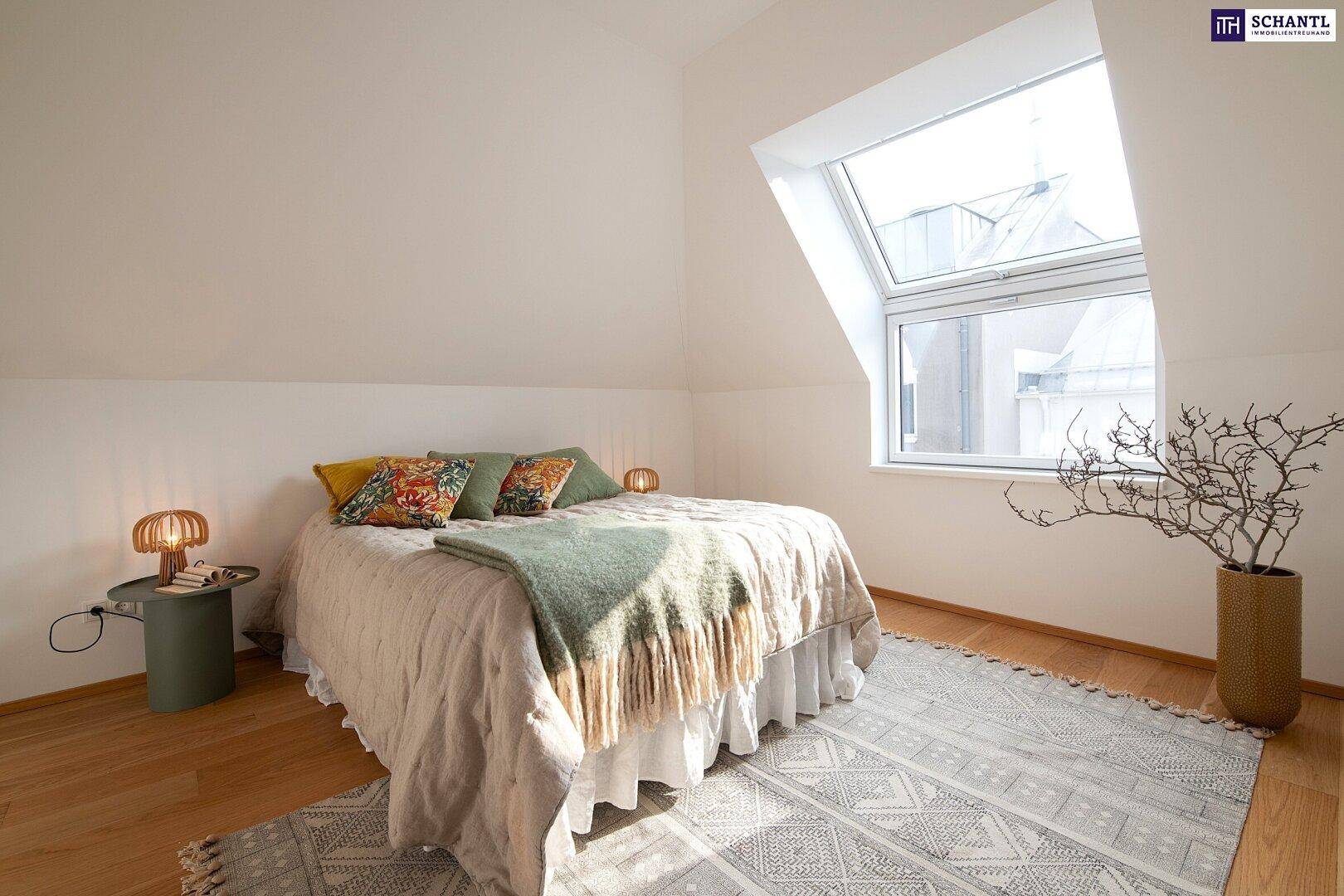 Gemütliches Schlafzimmer im Dachgeschoss mit großem Dachfenster und Holzboden.