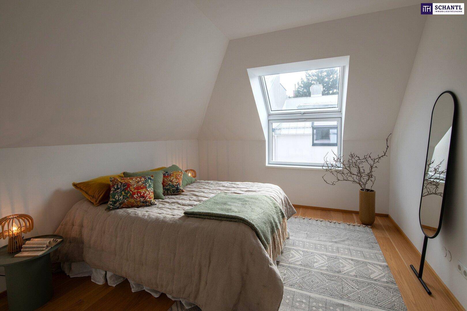 Helles Schlafzimmer im Dachgeschoss mit großem Dachfenster, Holzboden und Spiegel.