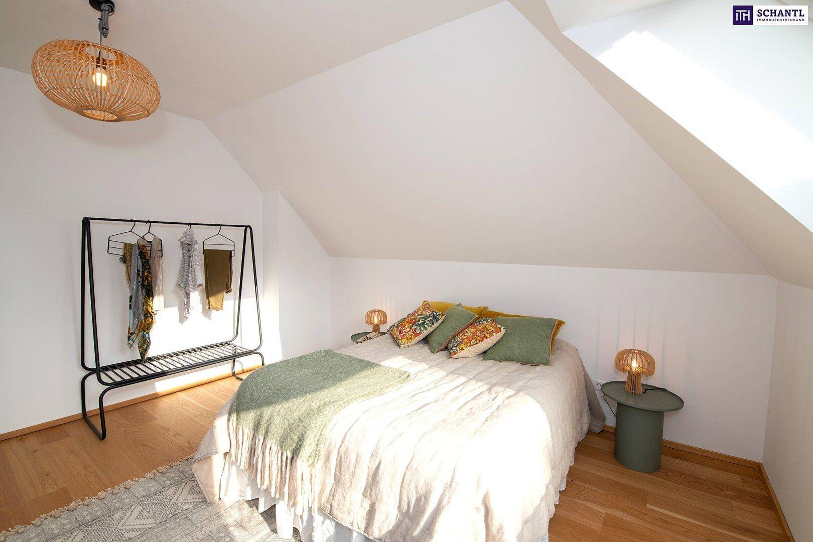 Helles Schlafzimmer mit Dachschräge, Holzboden und moderner Einrichtung.