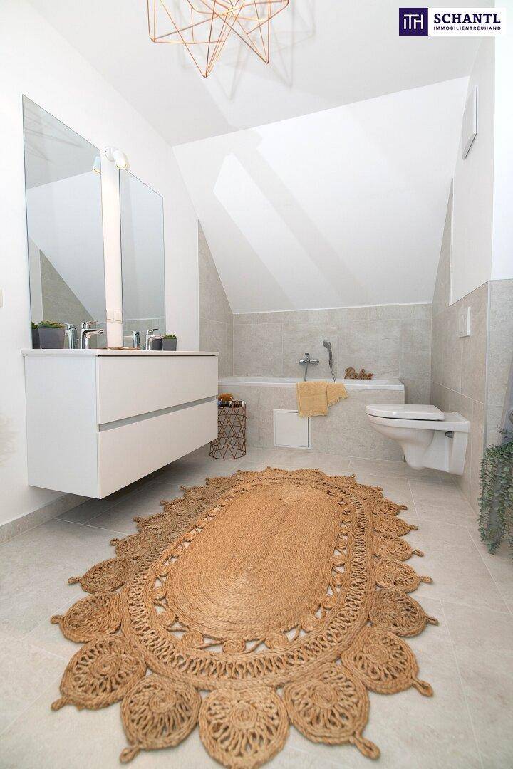 Modernes Badezimmer mit Badewanne, Hänge-WC und Waschtisch unter Dachschräge.