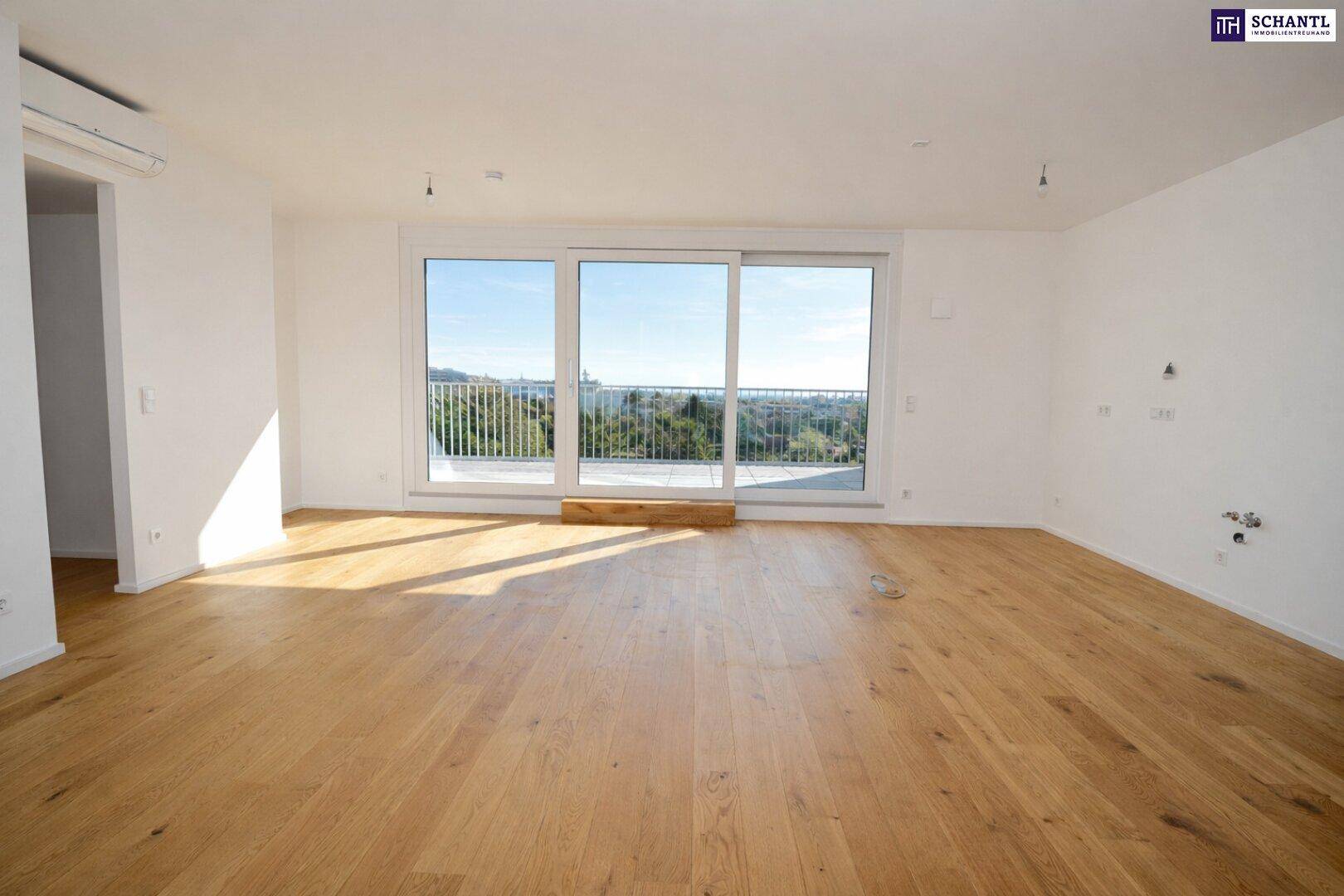Lichtdurchfluteter Wohnbereich mit Holzboden und breiter Schiebetür zur Terrasse.