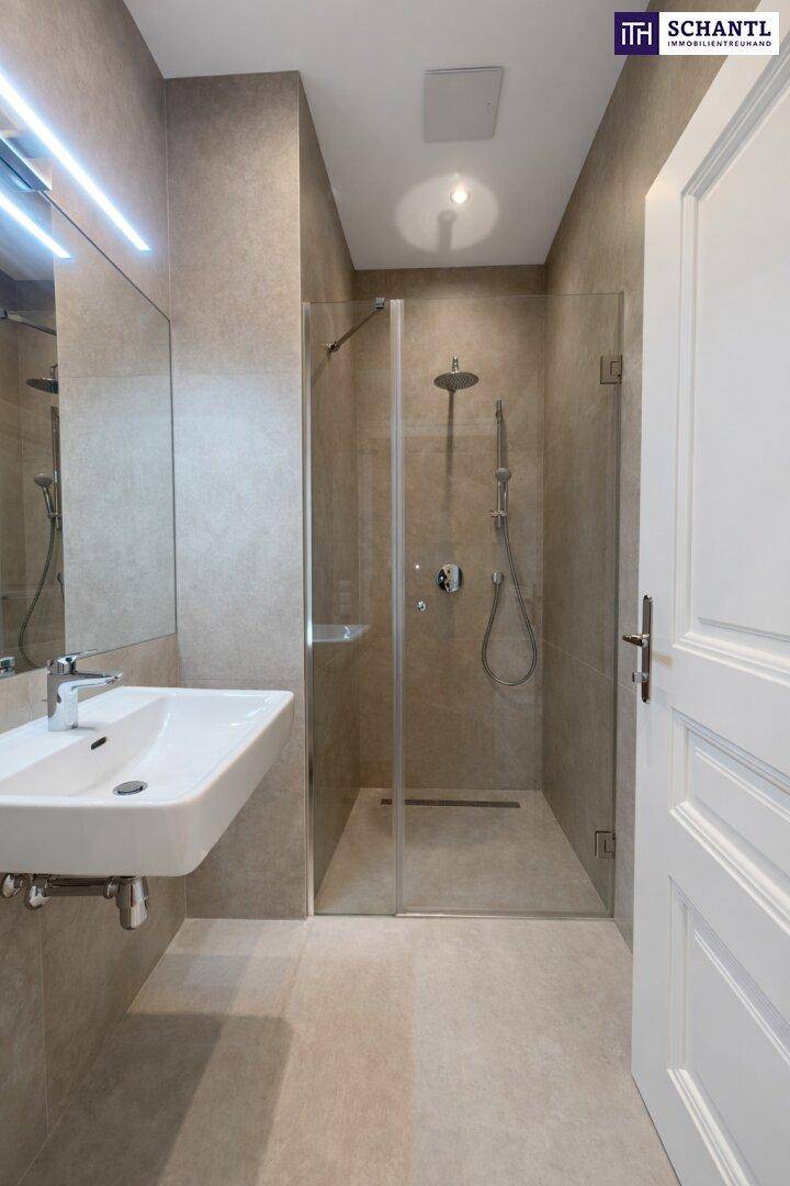 Modernes Badezimmer mit begehbarer Dusche, Wandwaschbecken und grauen Fliesen.