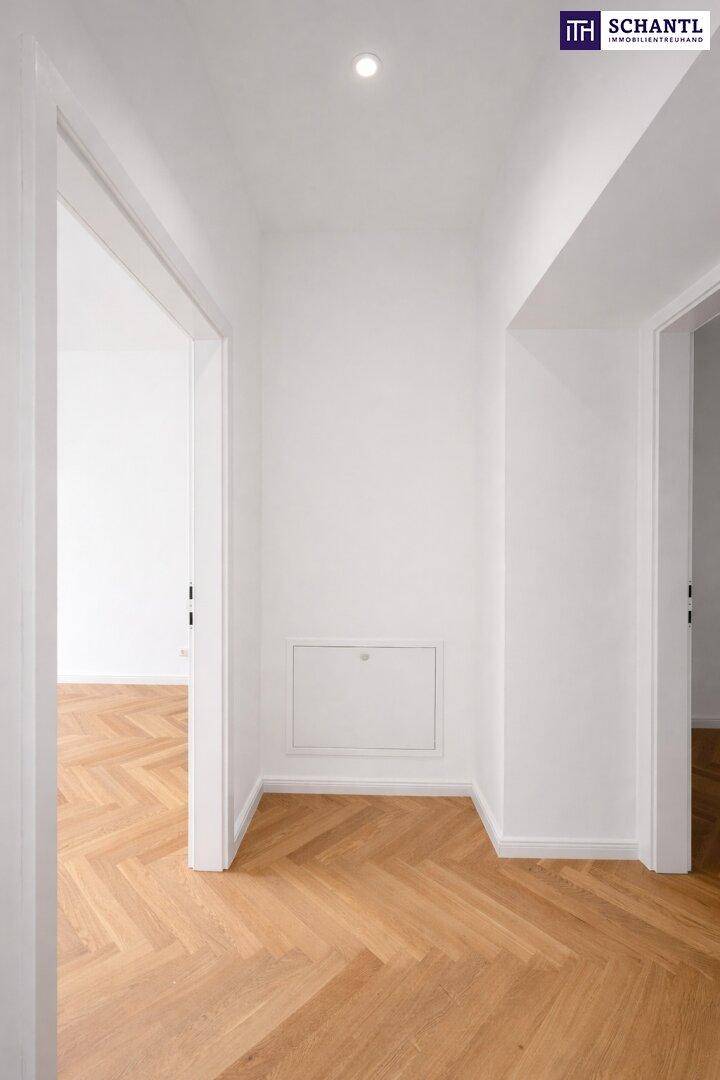 Heller Eingangsbereich mit Fischgrätparkett und Zugang zu weiteren Räumen.