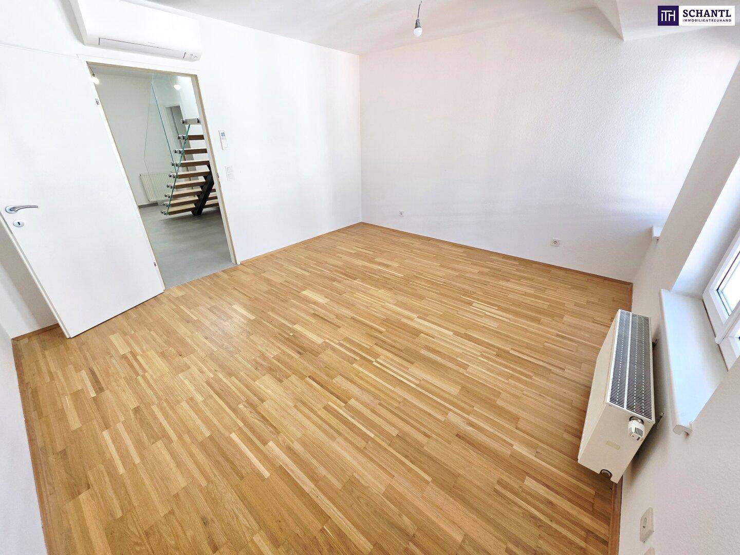 Helles Schlafzimmer mit Parkettboden und Heizkörper unter dem Fenster, bereit zur Einrichtung.