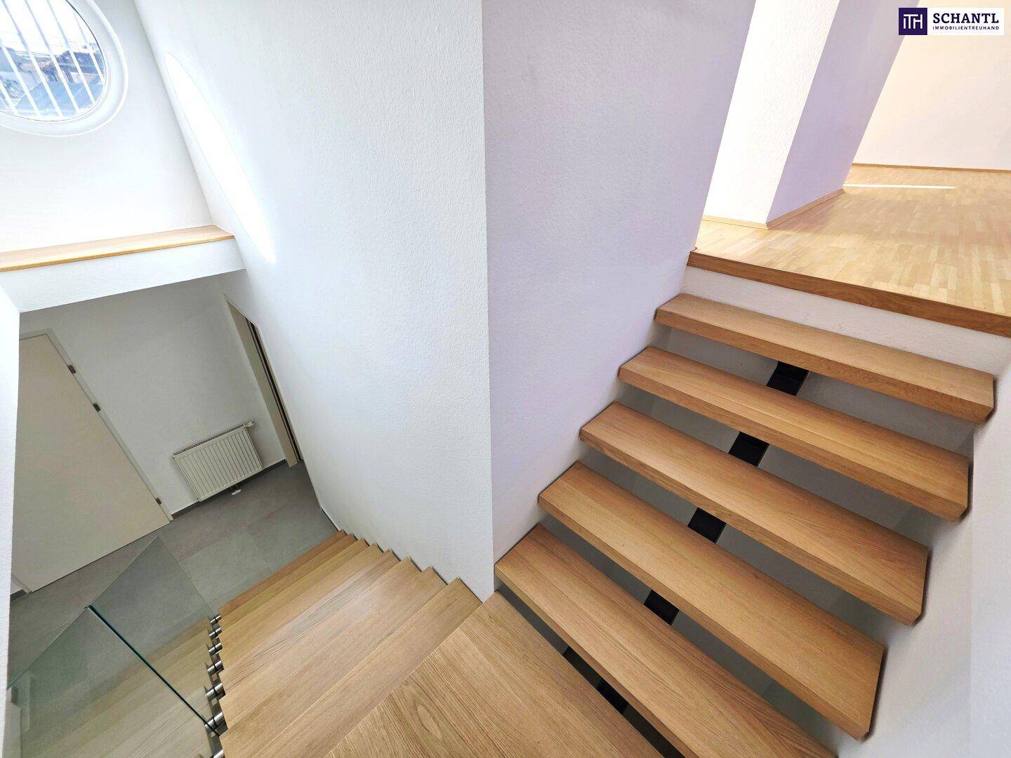 Helle Treppe mit Holzstufen und einem runden Oberlicht, das viel Tageslicht spendet.