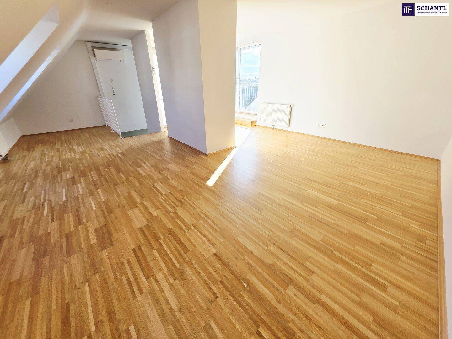Offene Wohnfläche mit hellem Parkettboden und viel Tageslicht, ideal für individuelle Gestaltung.