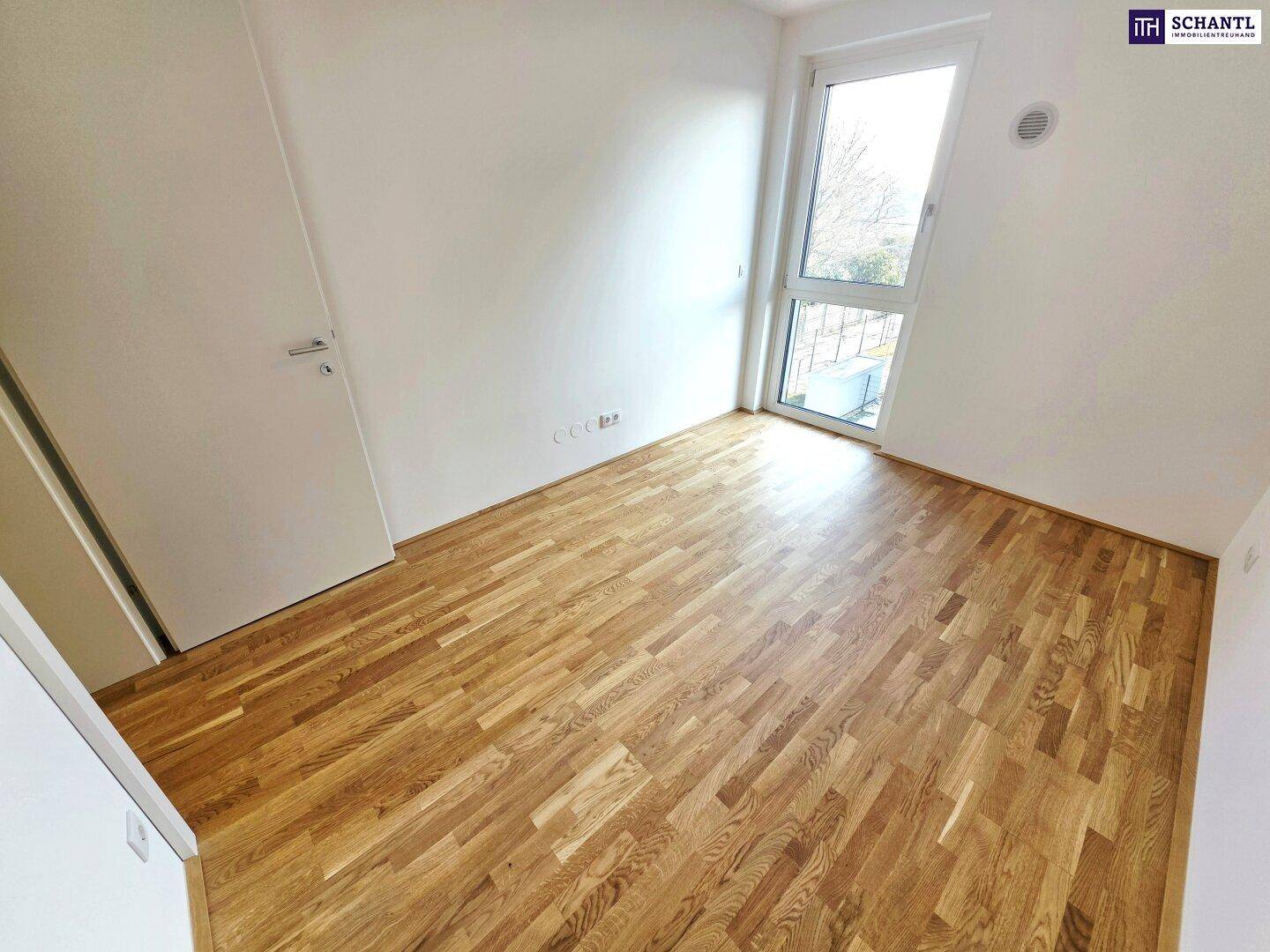 Helles Zimmer mit Parkettboden und großem Fenster, ideal als Schlafzimmer oder Kinderzimmer.