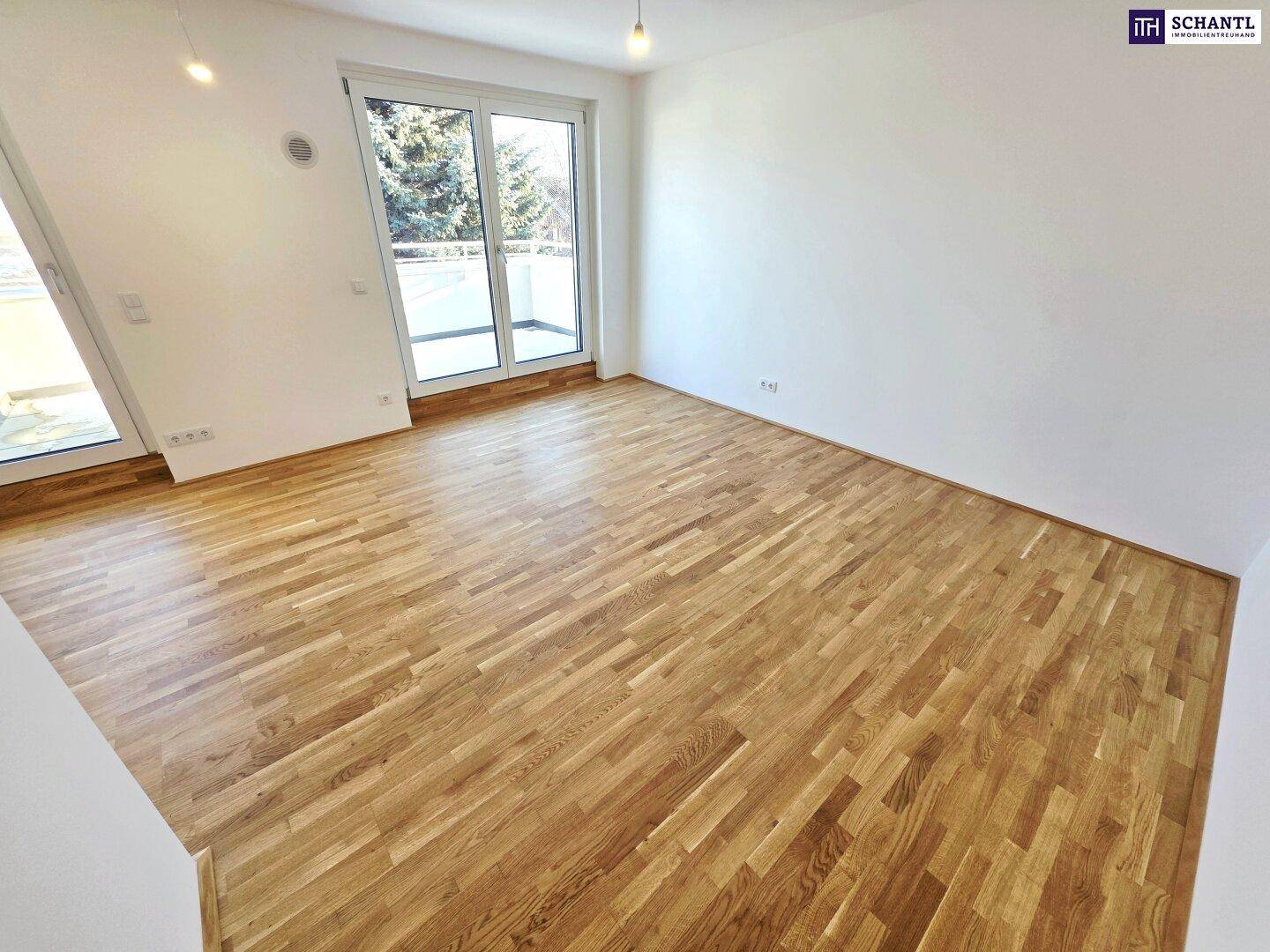 Heller Wohnbereich mit Parkettboden und Zugang zu einem sonnigen Balkon.