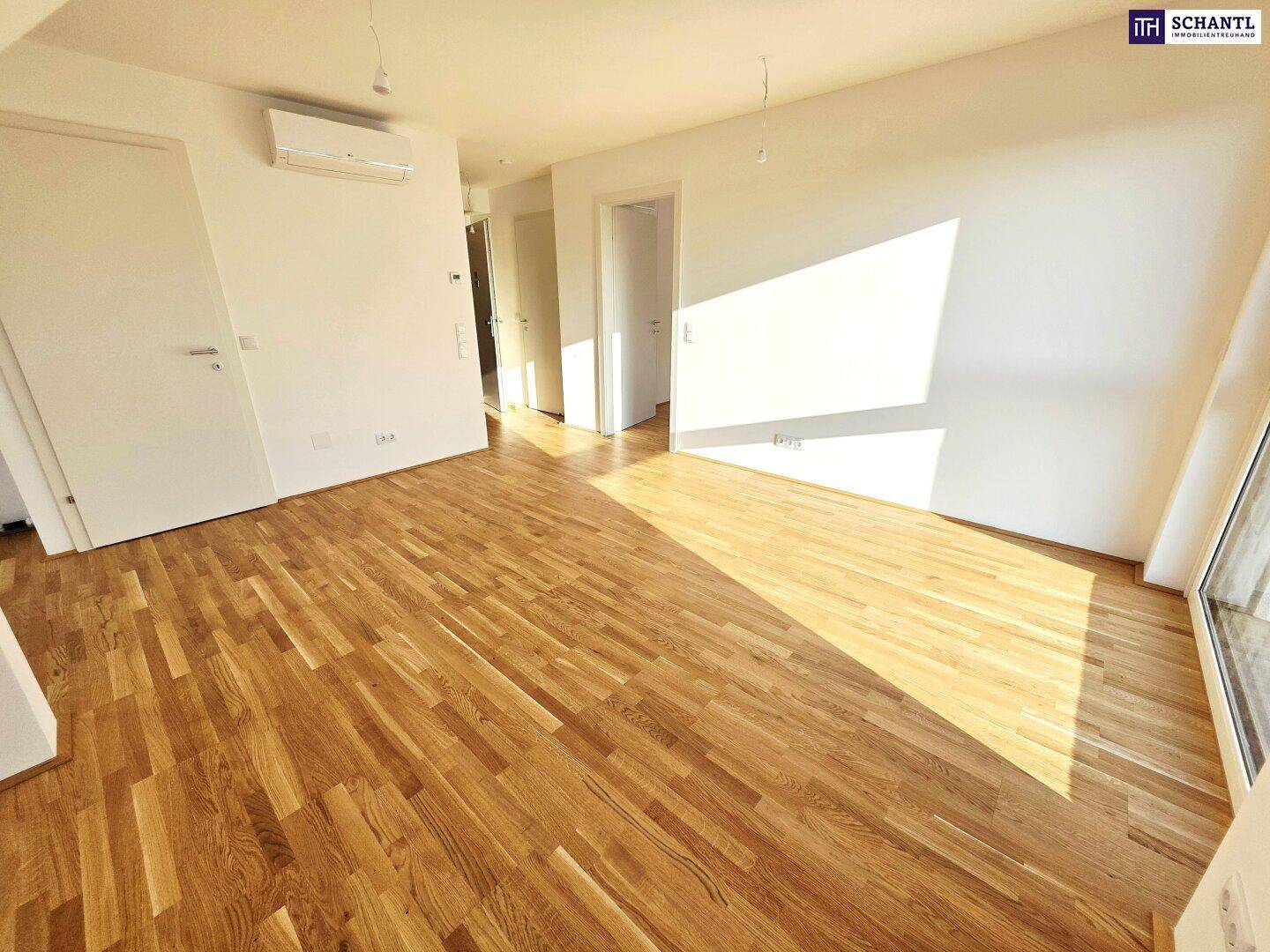 Heller Raum mit Holzboden und Klimaanlage, ideal für flexible Nutzung als Wohn- oder Schlafzimmer.