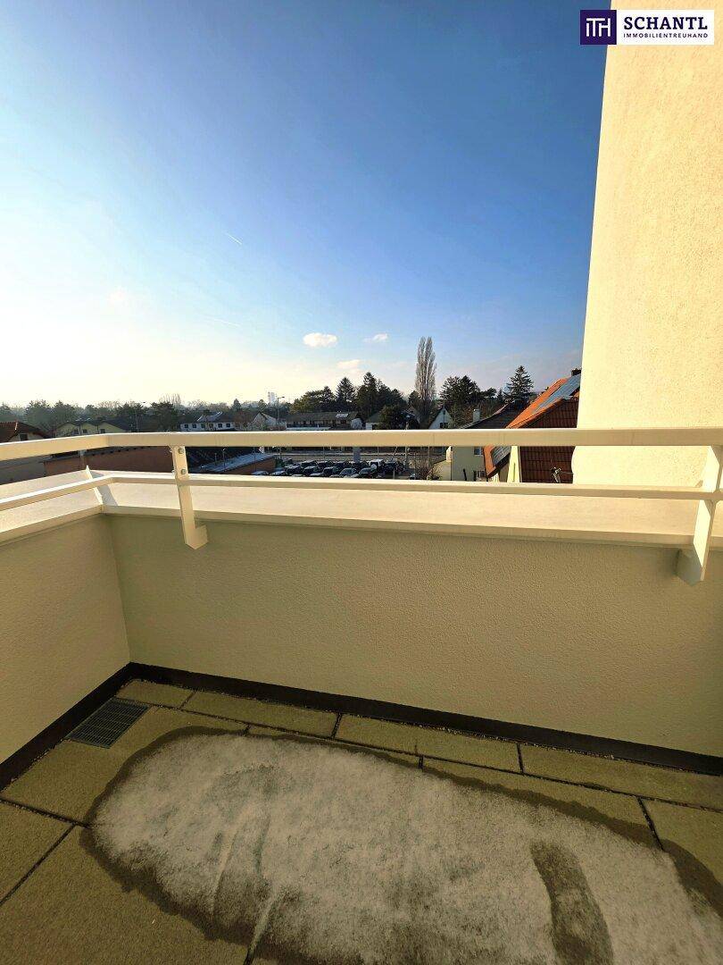 Sonniger Balkon mit Blick auf die Umgebung und teilweise verschneite Fliesen.