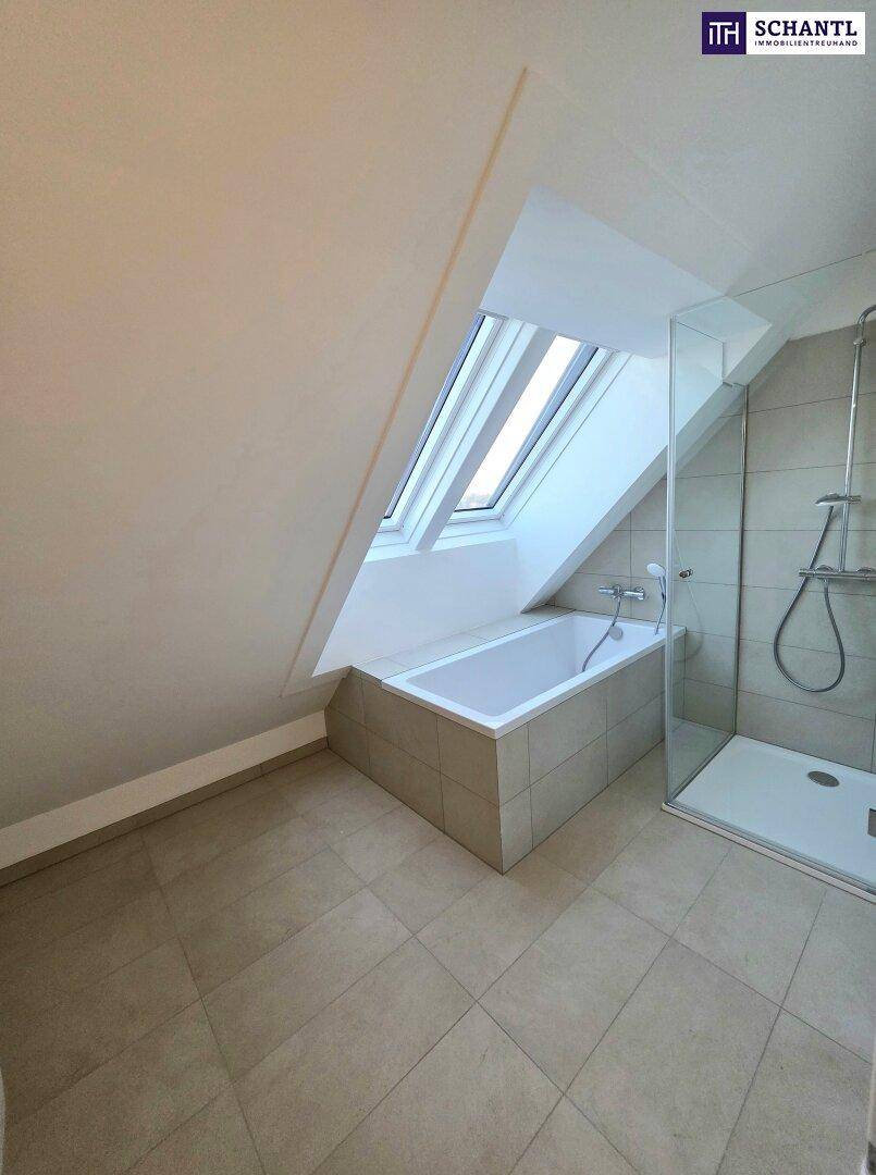 Modernes Badezimmer im Dachgeschoss mit Badewanne, Duschkabine und Dachfenster für natürliches Licht.