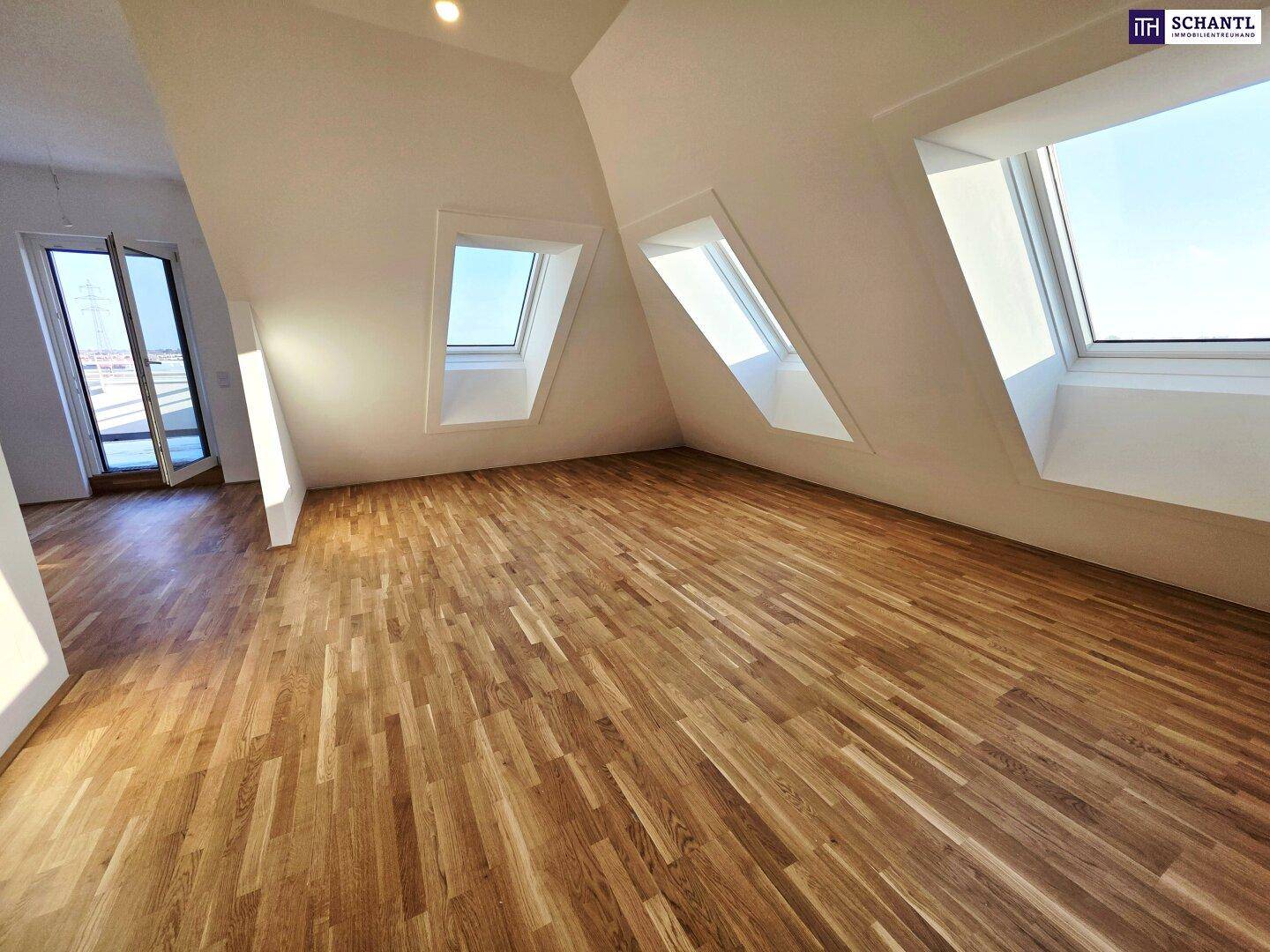 Geräumiger Raum im Dachgeschoss mit hellem Holzboden und schrägen Wänden, ideal für Wohnzwecke.